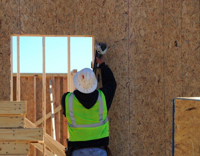 A construction worker secures a wall of a house at the Osprey Landing Neighborhood construction site on Hurlburt Field, Fla., Nov. 18, 2014. Once the homes are completed, they will be turned over to Corvias property management to be assigned to Hurlburt members and their families. (U.S. Air Force photo/Staff Sgt. Sarah Hanson)