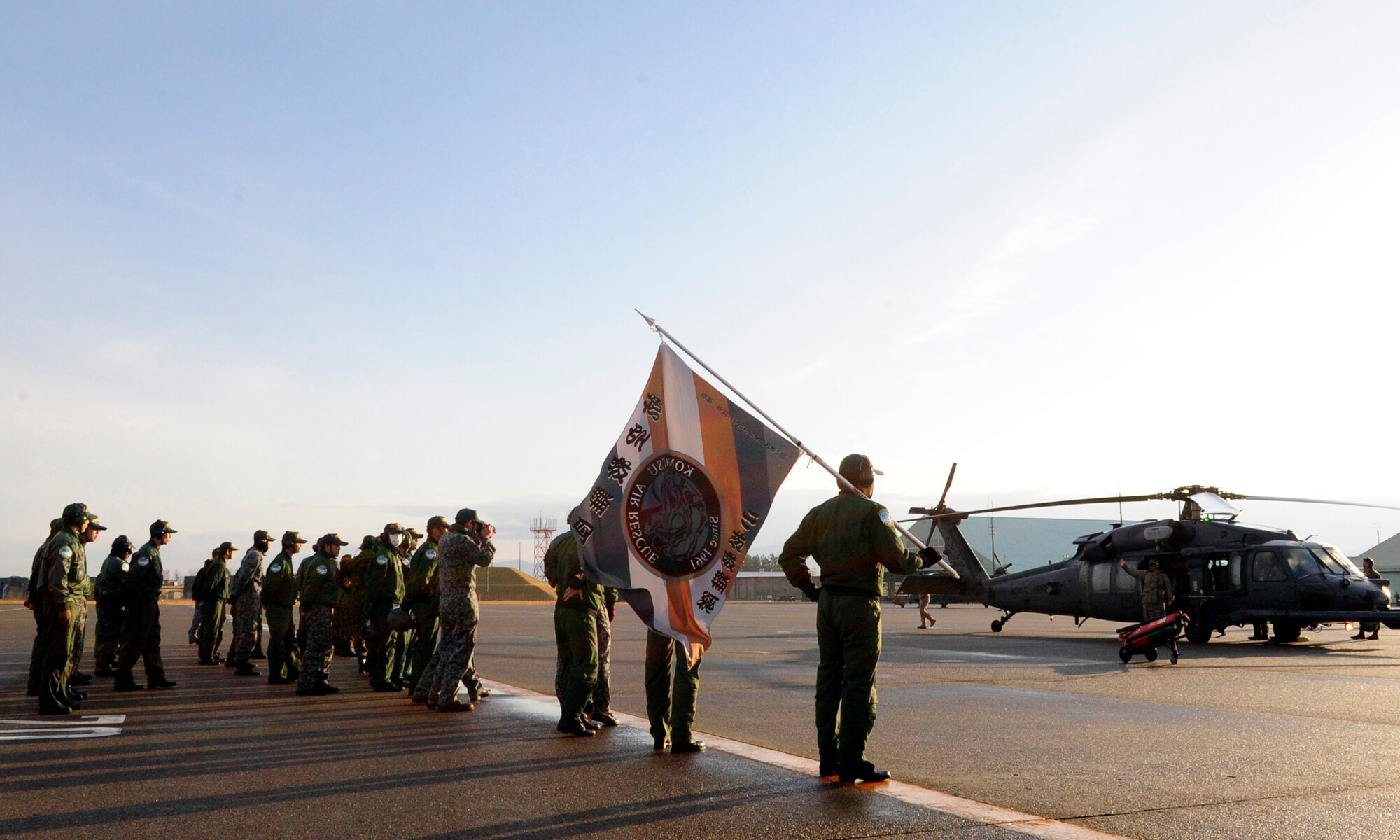 Members of the Komatsu Air Rescue Squadron gather to bid farewell to Kadena Air Base's 33rd Rescue Squadron on Komatsu Air Base, Japan, Nov. 16, 2014. Together, the rescue crews successfully completed multiple training missions during exercise Keen Sword, a biennial joint-bilateral field training exercise that increases the interoperability required to respond to a potential crisis and support the defense of Japan. (U.S. Air Force photo by 2nd Lt. Erik Anthony/Released)