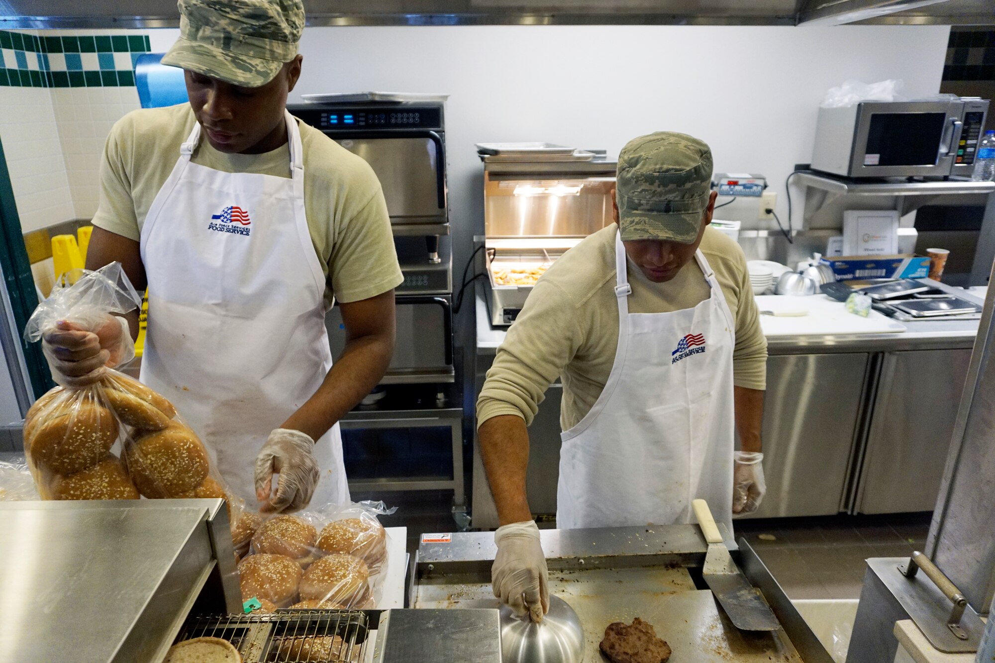 Staff Sgts. Lamarr Sherrod and Jeremy Torribio, 90th Force Support Squadron services specialists, work the U-food grill station Nov. 17, 2014, in the Chadwell Dining Facility, F.E. Warren Air Force Base, Wyo. The station provides fresh alternatives to common foods, included baked fries, lean burgers and grilled chicken entrees. (U.S. Air Force photo/Lan Kim)