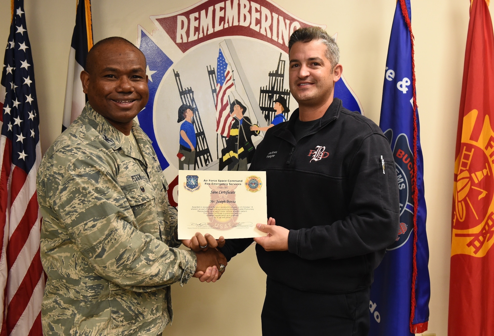 Joseph Boscia, Buckley Fire Emergency Services, receives an Air Force Space Command Fire Emergency Services Save Certificate from Col. George Petty, AFSPC Civil Engineer Readiness and Emergency Management chief, Nov. 20, 2014, at the fire department on Buckley Air Force Base, Colo. Boscia and three other firefighters were awarded for their lifesaving actions while responding to a major vehicle accident in October 2014. (U.S. Air Force photo by Tech. Sgt. Kali L. Gradishar/Released)