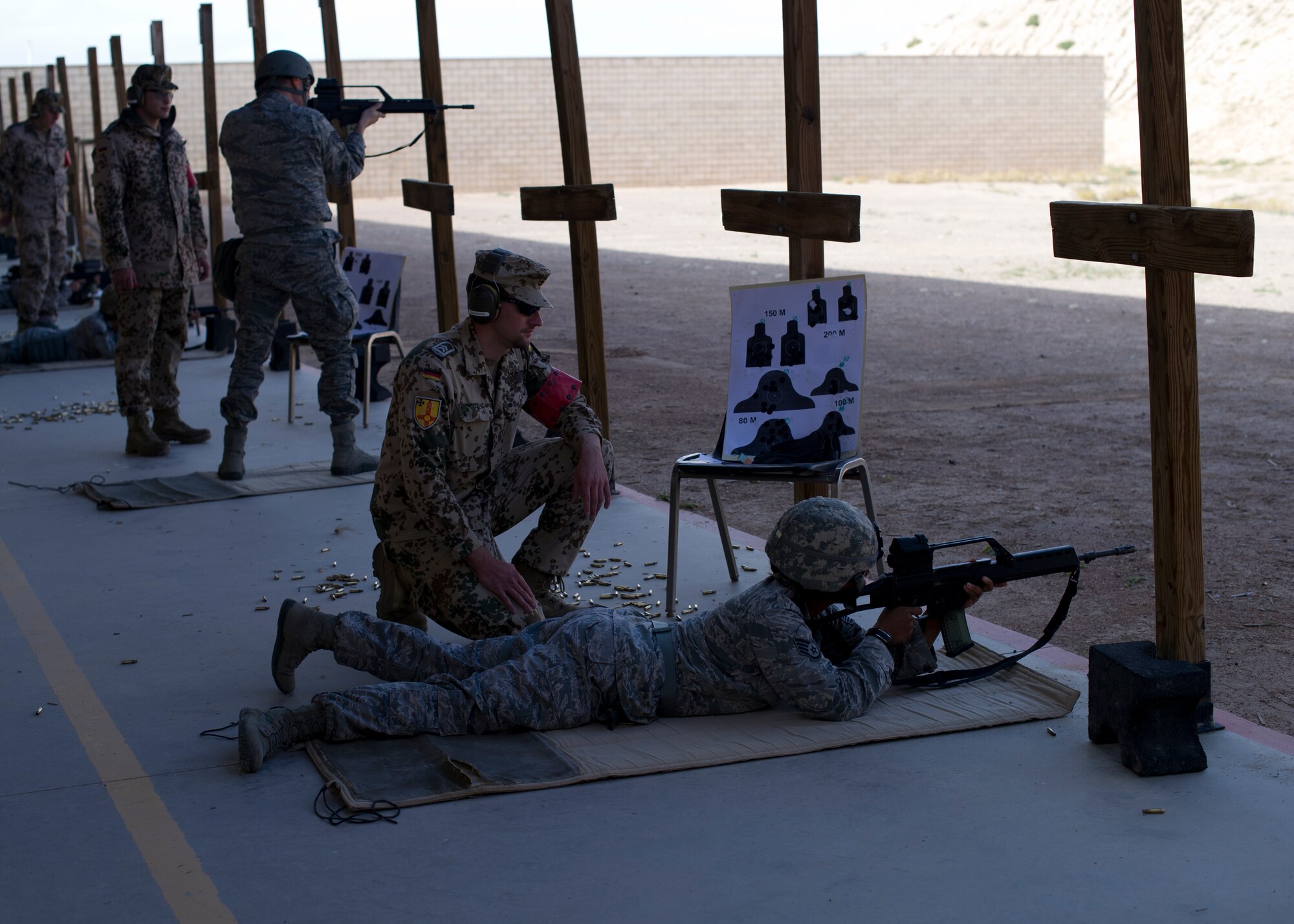 German Air Force weapons assistants guide Holloman Airmen during a shooting event at Holloman Air Force Base, N.M., Nov. 12. Both countries had over 25 participants shooting each other’s weapons at the Combat Arms and Maintenance facility for the chance to qualify and receive marksmanship on the German G36 rifle and P8 Pistol, as well as the American M-4 Rifle and M-9 Pistol. The event was held to provide weapon familiarization as well as a bonding opportunity between both countries.  (U.S. Air Force photo by Senior Airman Leah Ferrante/released)