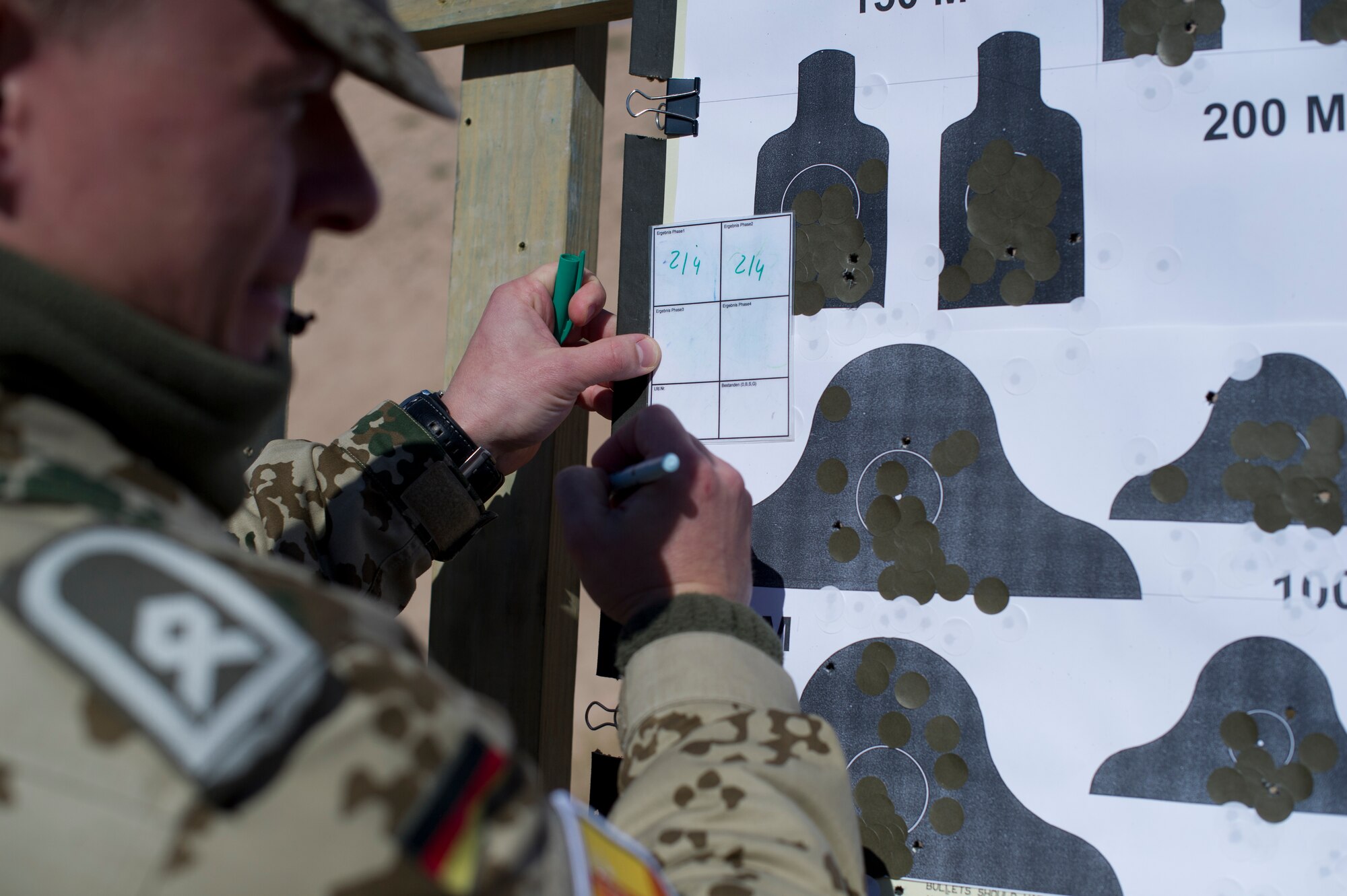 Master Sgt. Marcus Pretzsch, German Air Force weapons assistant, marks all the confirmed hits during an event at Holloman Air Force Base, N.M., Nov 12. Holloman Airmen had the opportunity to shoot the German G36 Assault Rifle and the P8 Pistol for the chance to qualify for the Schutzenschnur Marksmanship Badge. The event was held to improve an already established bond between the German and American Air Forces, and also to give the Airmen weapons familiarization in preparation for real-world applications. (U.S. Air Force photo by Senior Airman Leah Ferrante/released)