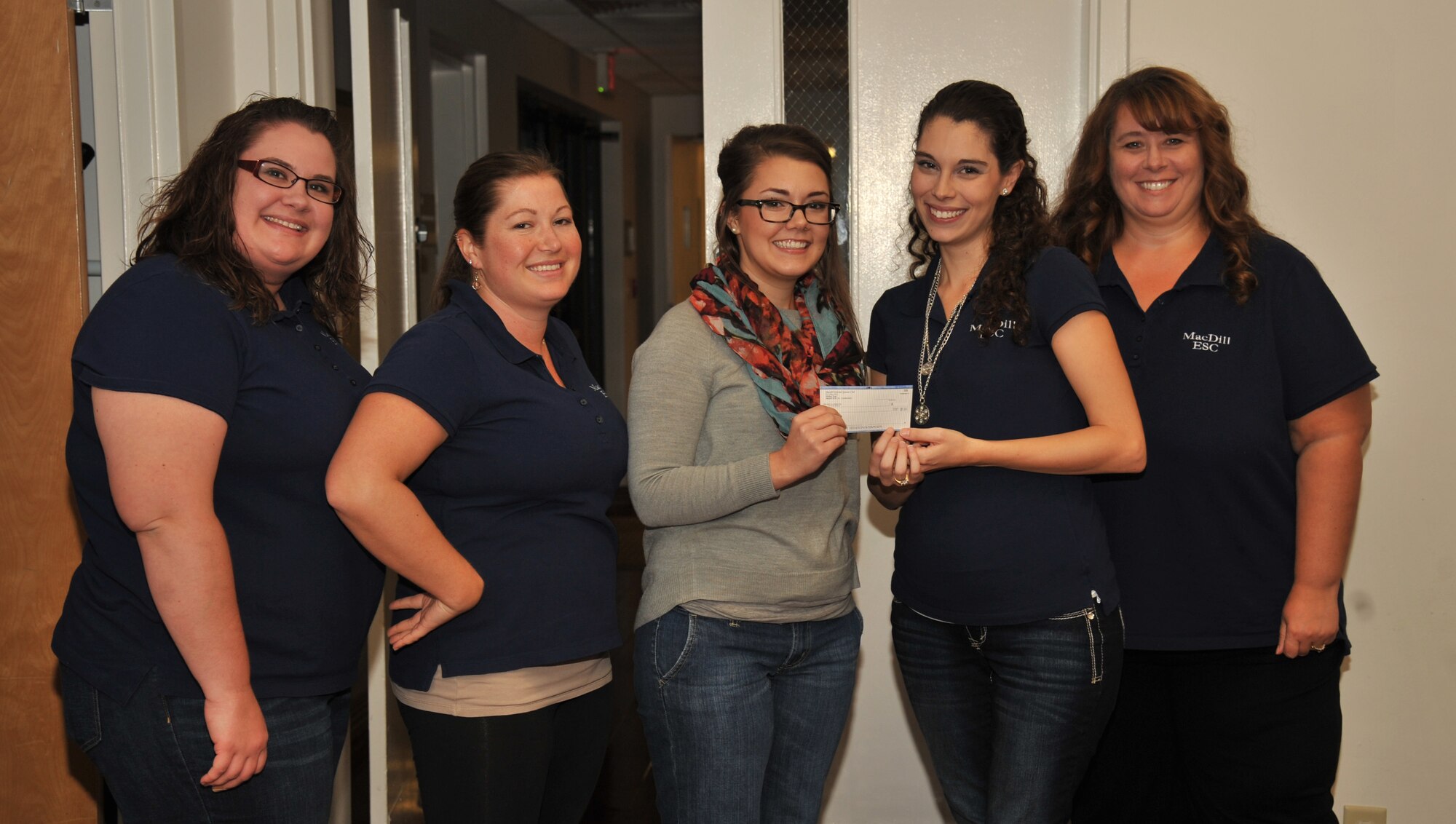 The Enlisted Spouses Club board members present a $1,000 scholarship to Rachel Pittner, spouse and nursing student, Nov. 20, 2014, at MacDill Air Force Base, Fla. This is the enlisted spouses club first time awarding a scholarship to a spouse. (U.S. Air Force photo by Staff Sgt. Brittany Liddon/Released)