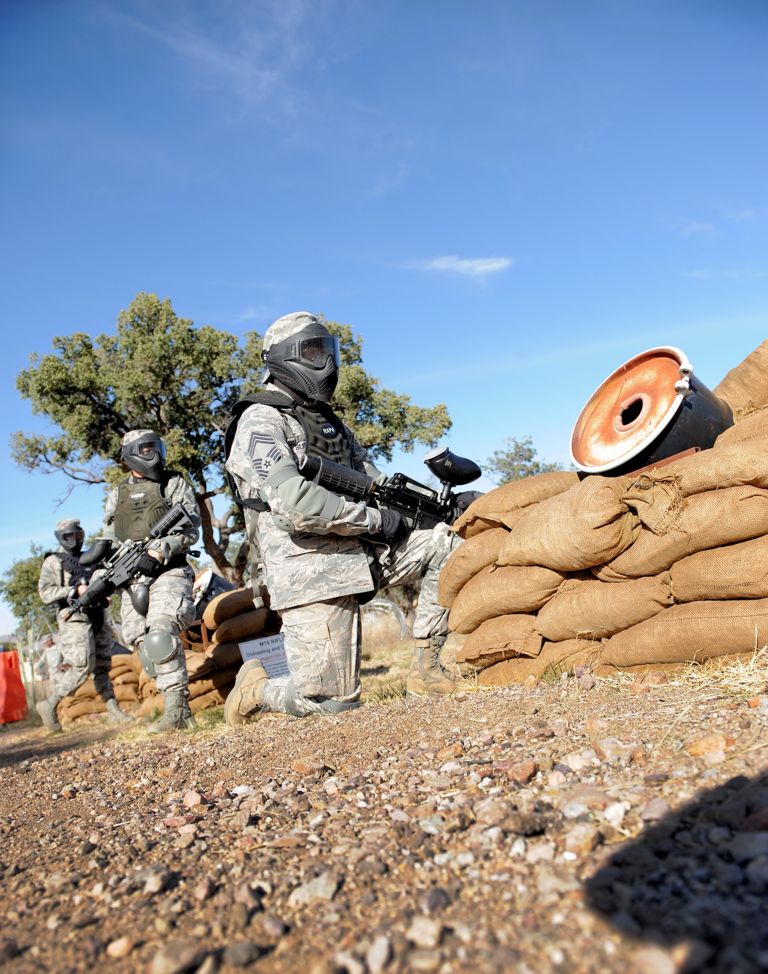 U.S. Air Force Airmen wait for further instruction during a field training exercise at Fort Huachuca, Ariz., Nov. 18, 2014. The Airmen were challenged to defend against simulated opposing forces using paintball guns and Army ground tactics during the Army Weather Support Course. (U.S. Air Force photo by Airman 1st Class Chris Drzazgowski/Released)