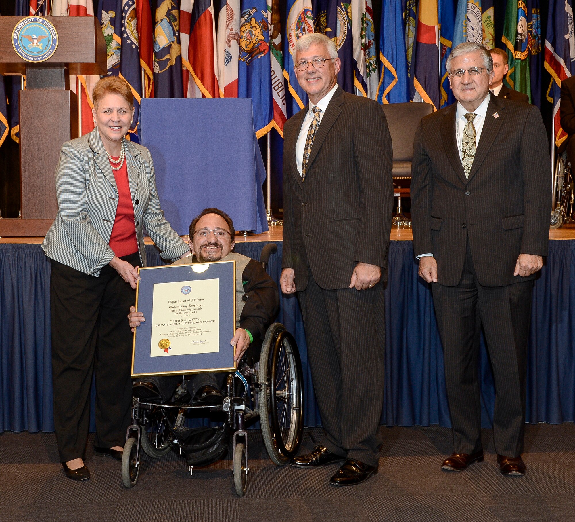 Under Secretary for Defense Jessica Garfola, Principal Deputy Assistant Secretary for Manpower and Reserve Affairs Daniel Sitterly and Assistant Deputy Chief of Staff for Manpower, Personnel and Services Robert Corsi present Chris Gitto with the 2014 DOD Disability Award during a ceremony Oct. 30, 2014, at the Pentagon. The DOD Disability Awards ceremony honors service components for outstanding achievements in the hiring, retention and advancement of individuals with disabilities. Gitto is a technical information specialist from Kirkland Air Force Base, N.M. (U.S. Air Force photo/Andy Morataya)