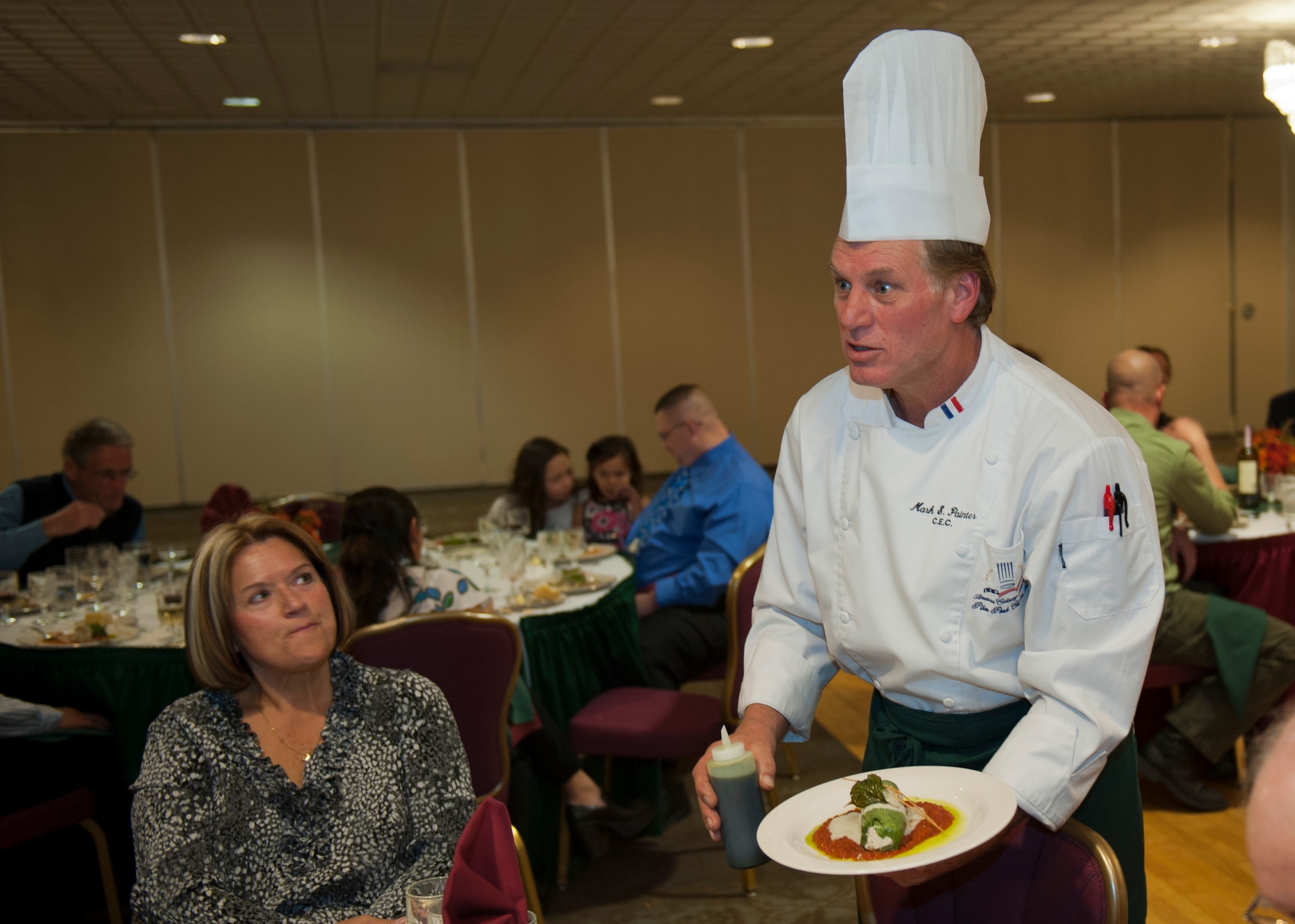 PETERSON AIR FORCE BASE, Colo. – Chef Mark Painter, certified executive chef and instructor at Pikes Peak Community College, displays and explains his presentation of the roasted chicken cannelloni during the Celebrity Guest Chef Dinner at the Club Nov. 14. Guests paid $45 to experience a gourmet four course meal prepared by Painter and see a demonstration of how a few of the dishes were created. (U.S. Air Force photo/Airman 1st Class Rose Gudex)