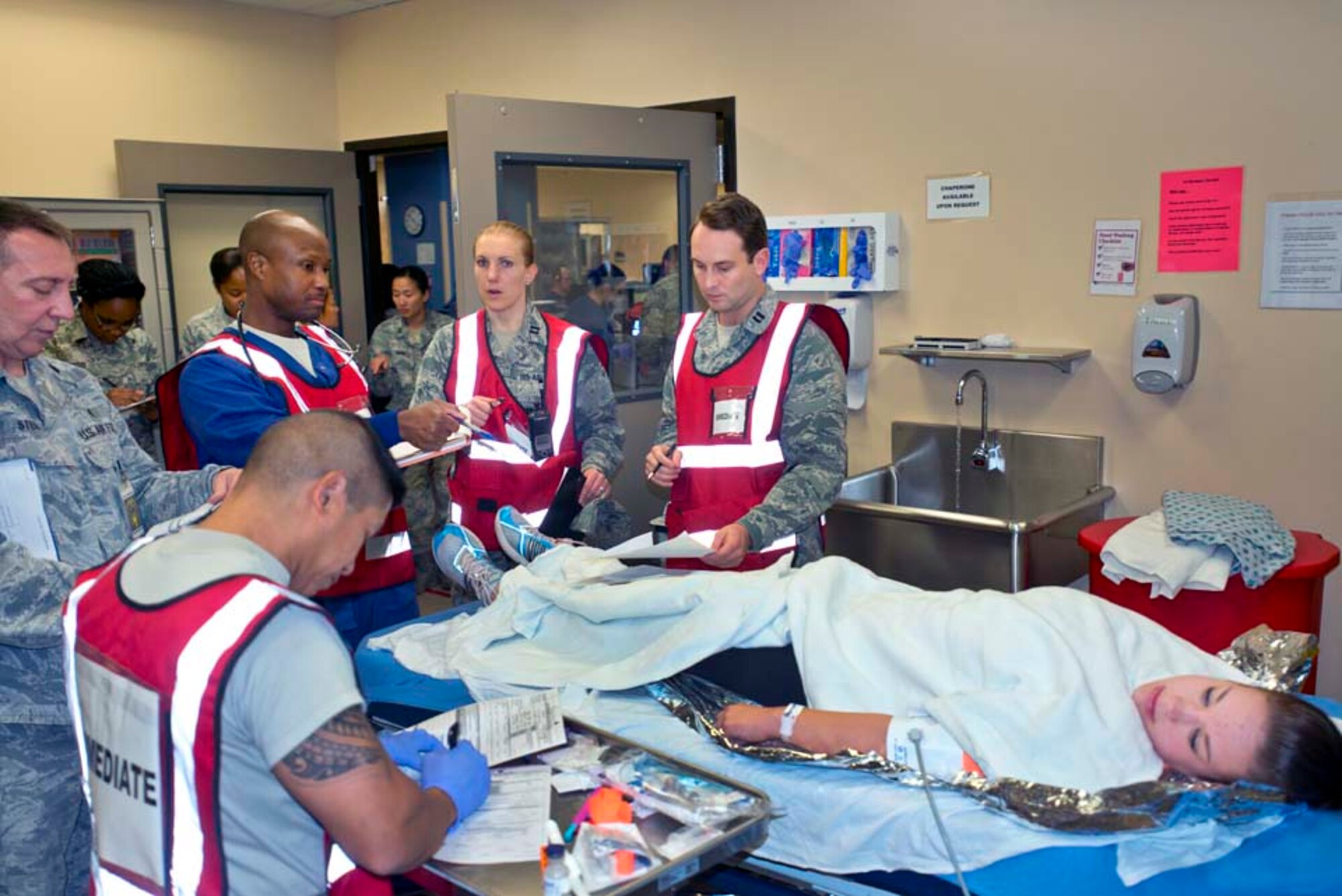 Airmen from the 60th Medical Group examine a simulated victim during an active-shooter exercise Nov. 18, 2014, at Travis Air Force Base, California. (U.S. Air Force photo by T.C. Perkins Jr.)