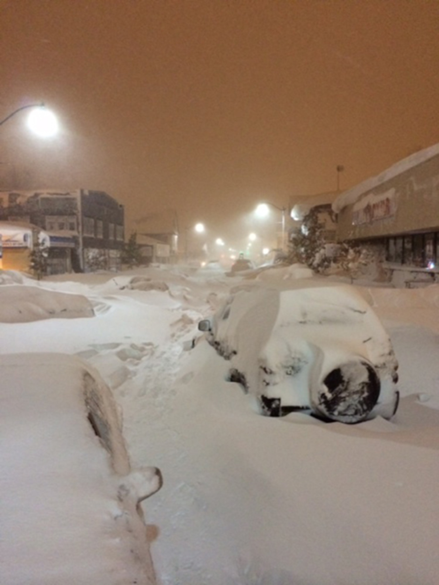 A South Buffalo street is littered with abandoned vehicles and snow at the intersection of Tifft Street and South Park Avenue on November 20, 2014.  Impossible to drive even with four wheel drive vehicles, snowmobiles in some cases substituted for ambulances during a lake effect snow storm that brought close to 8 feet of snow in three days. (Photo by Aaron Mclane)