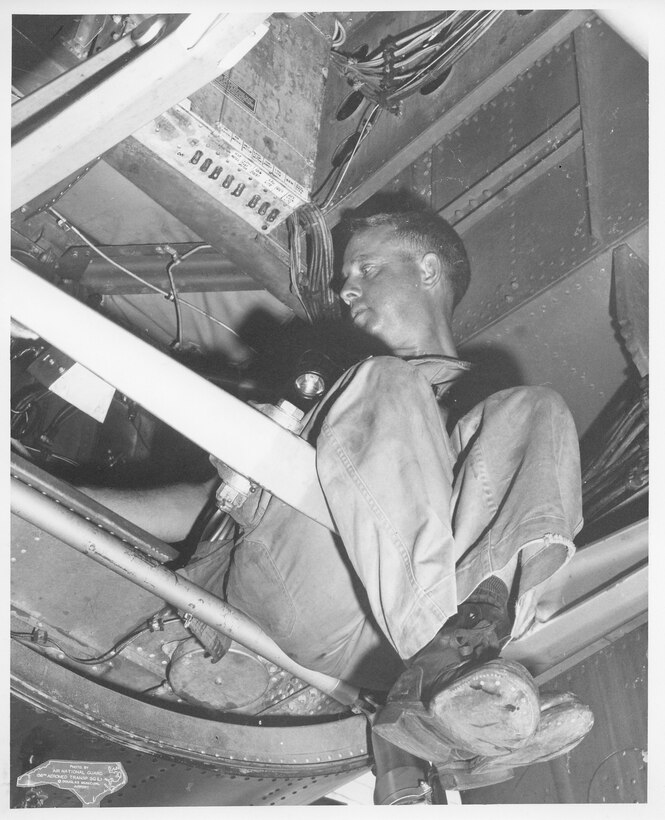 C-119 31 Jan 1961 - 19 Dec 1962; C-119 in Hanger.  Bill McFall performing Maintenance Inspection on a C-119 (Photo by NCANG Heritage Program)