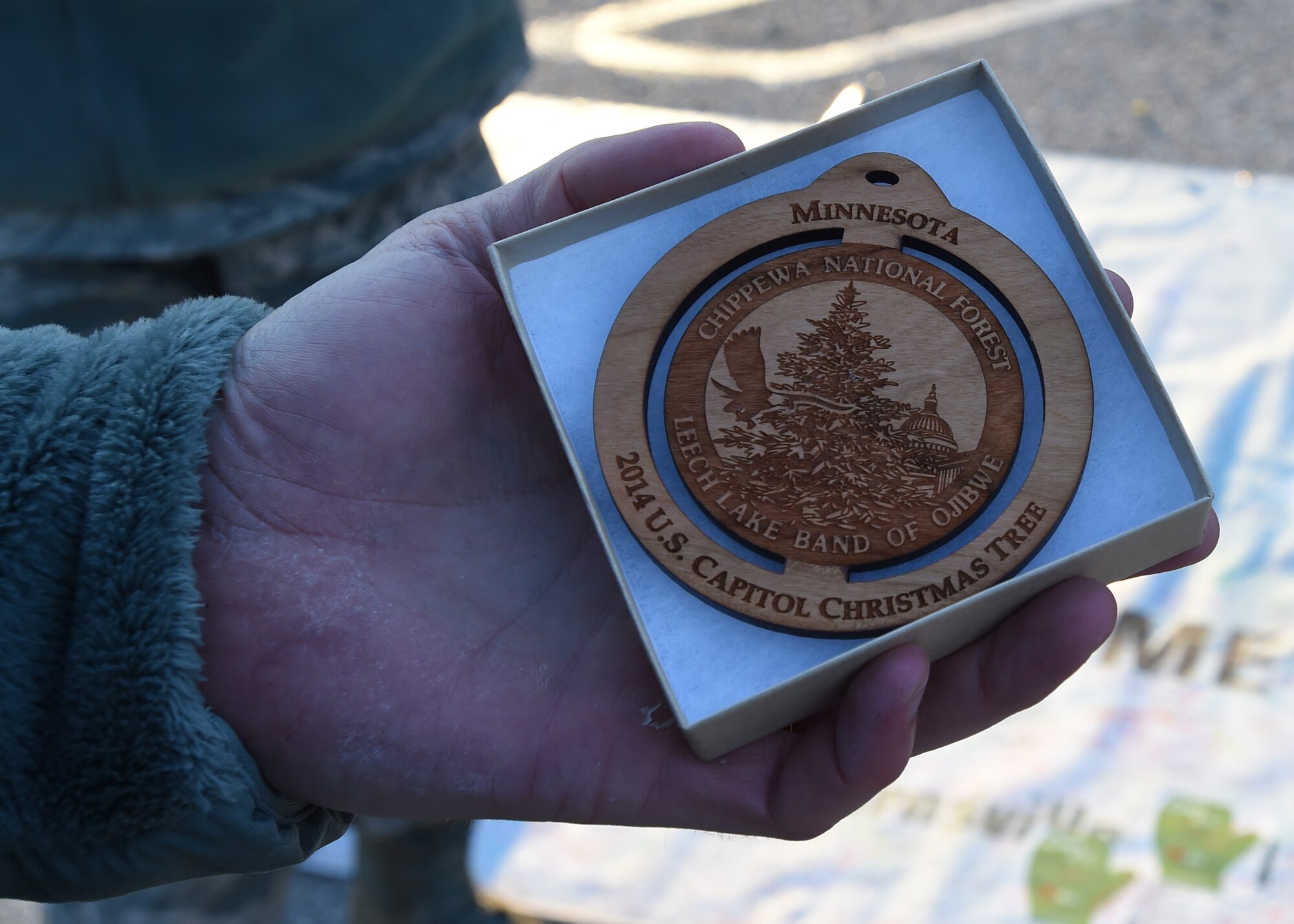 Col. Daniel Waters, 11th Wing commander, holds a Christmas tree ornament at the 2014 U.S. Capitol Christmas Tree arrival on Joint Base Andrews, Md., Nov. 20, 2014. Chippewa National Forrest members gave out ornaments while thanking military members and their families for their service. (U.S. Air Force photo/ Senior Airman Nesha Humes)
