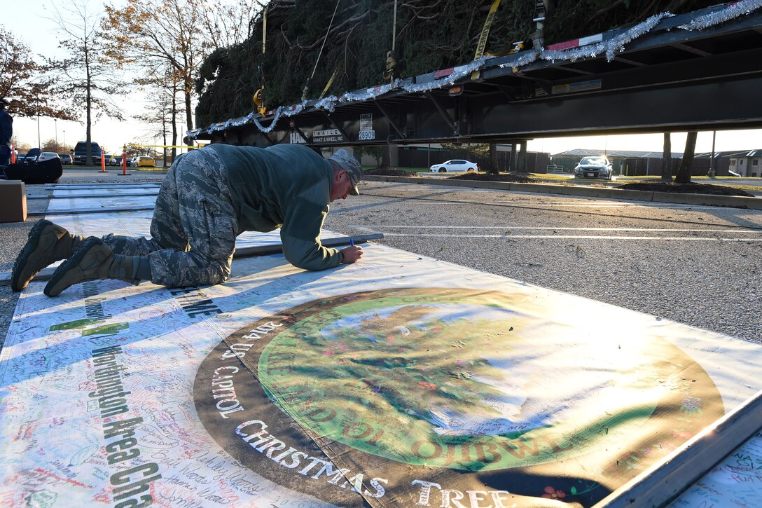 Chief Master Sgt. Vance Kondon, 11th Wing command chief, signs his name on the 2014 U.S. Capitol Christmas Tree’s banner on Joint Base Andrews, Md., Nov. 20, 2014. As the U.S. Capitol Christmas tree traveled 2,000 miles from Chippewa National Forest in Minnesota, people from each of the 30 stops signed the 65-foot banner. (U.S. Air Force photo/ Senior Airman Nesha Humes)