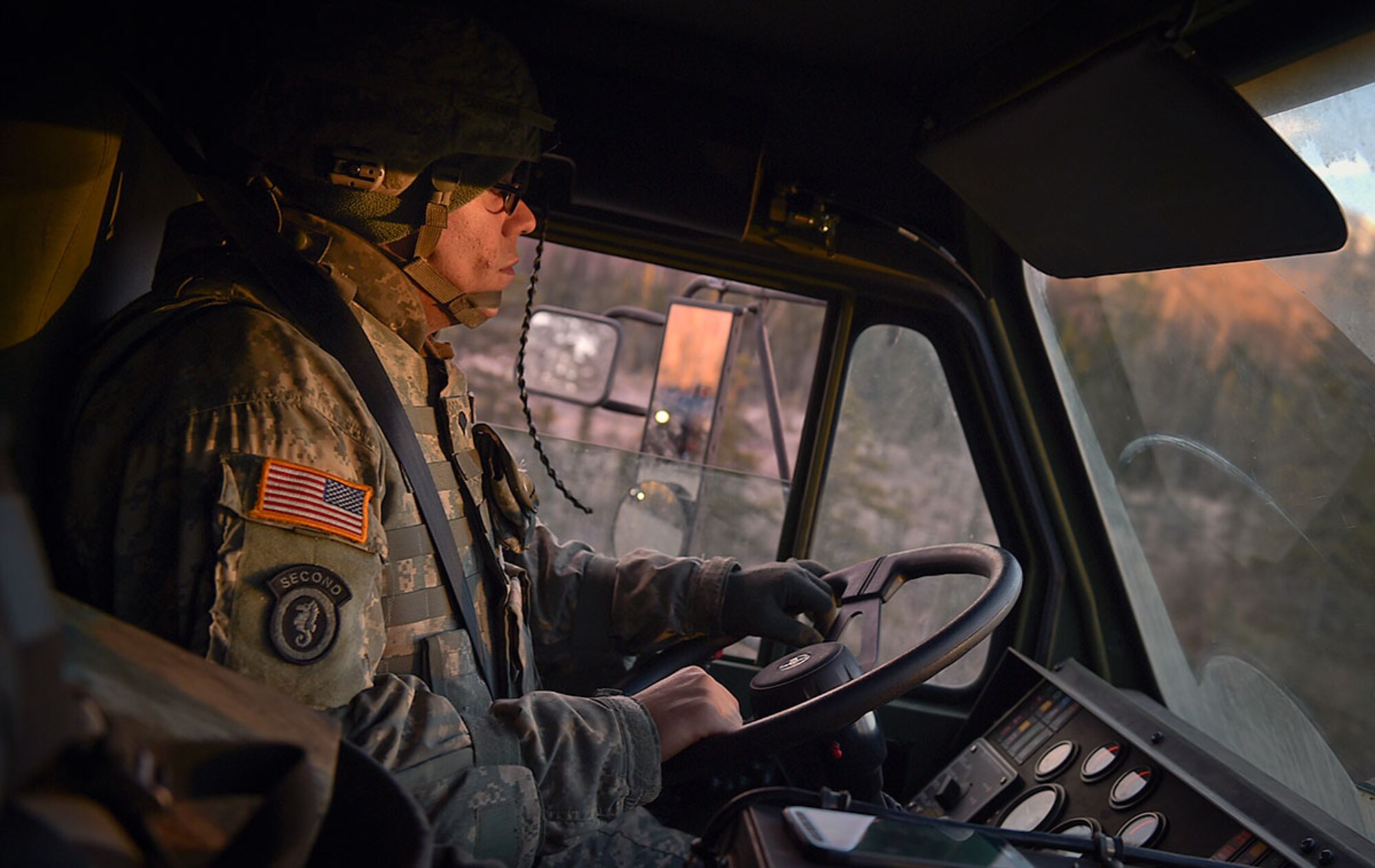 Spc. Israel Santiago, a native of Bristol, Penn., assigned to U.S. Army Alaska's 109th Transportation Company, Thursday, Nov. 13, 2014, drives a vehicle during preparation for a convoy live-fire exercise. The transportation soldiers also simultaneously executed react-to-ambush procedures with follow-on hasty and deliberate vehicle recovery operations. (U.S. Air Force photo/Justin Connaher)