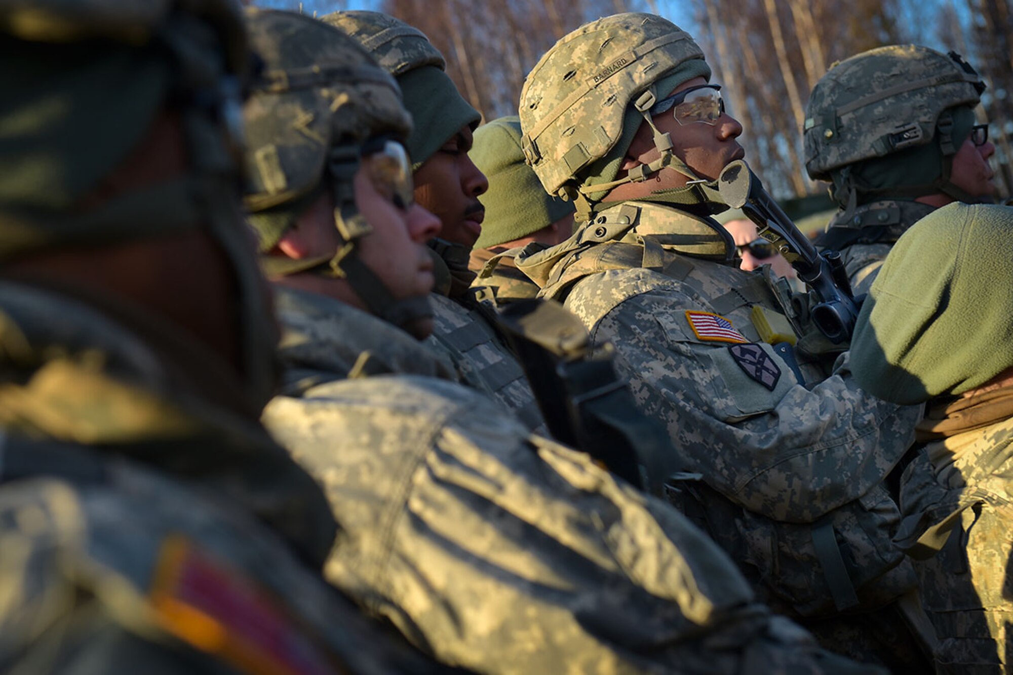 Spc. Ricky Barnard, assigned to U.S. Army Alaska's 109th Transportation Company, listens to a briefing, Thursday, Nov. 13, 2014, in preparation for a convoy live-fire exercise. The soldiers also simultaneously executed react-to-ambush procedures with follow-on hasty and deliberate vehicle recovery operations. (U.S. Air Force photo/Justin Connaher)