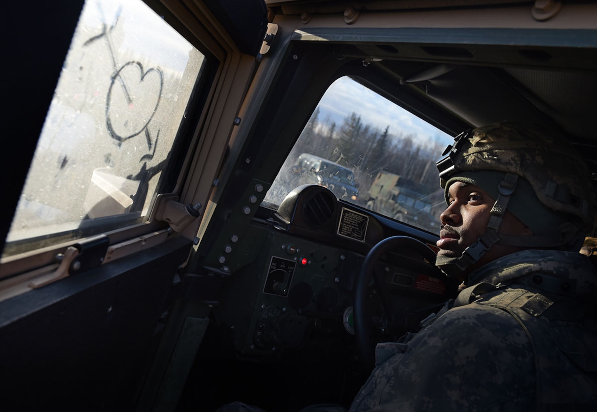 Spc. Christopher Lee, a native of St. Louis, assigned to U.S. Army Alaska's 109th Transportation Company, closes the driver's door of his HMMWV, Thursday, Nov. 13, 2014, on Joint Base Elmendorf-Richardson, Alaska, during a convoy live-fire exercise.  The soldiers also simultaneously executed react-to-ambush procedures with follow-on hasty and deliberate vehicle recovery operations.  (U.S. Air Force photo/Justin Connaher)