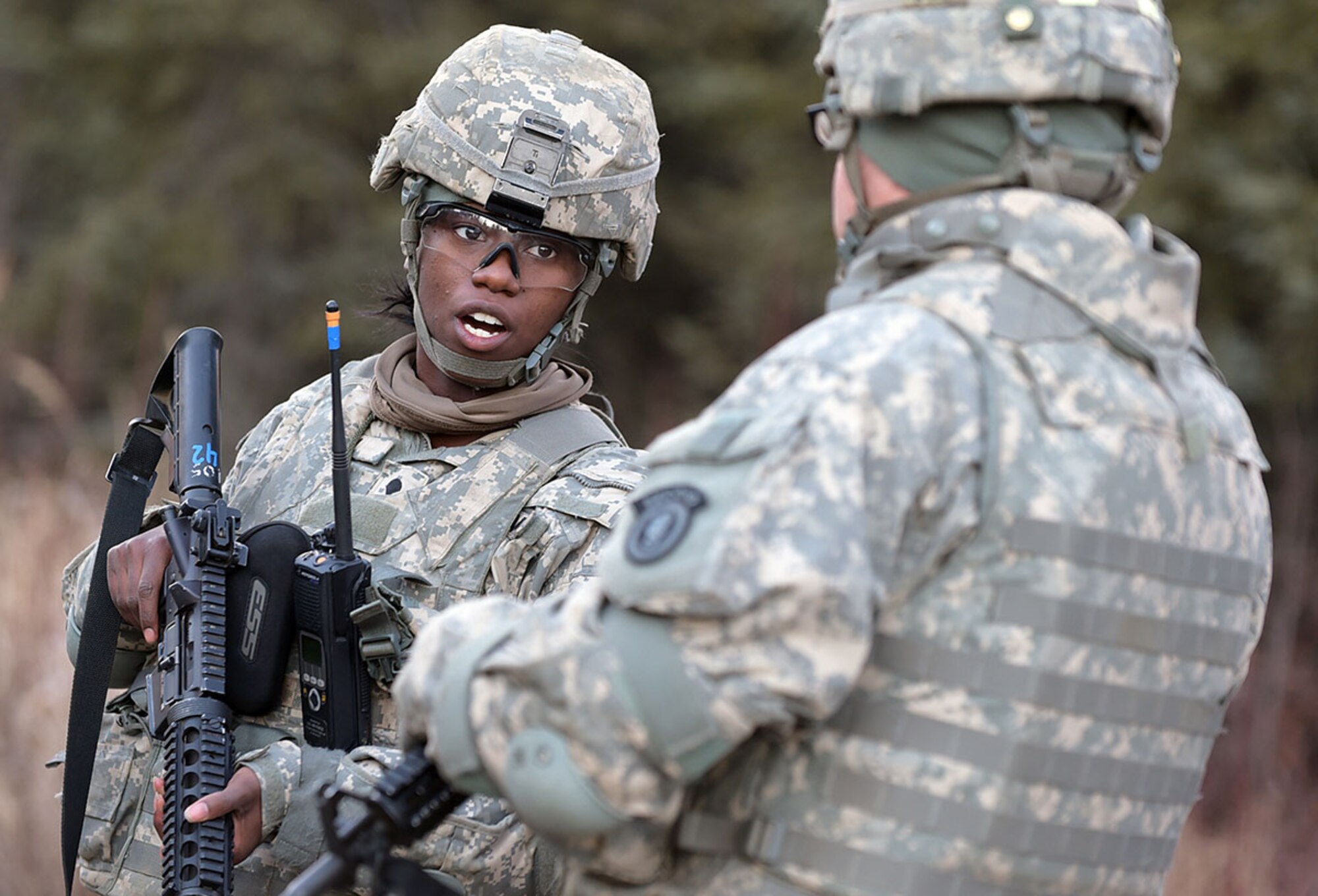 Spc. Farrah Bell, assigned to U.S. Army Alaska's 109th Transportation Company, talks with another soldier, Thursday, Nov. 13, 2014, on Joint Base Elmendorf-Richardson, Alaska, in preparation for a convoy live-fire exercise. The soldiers also simultaneously executed react-to-ambush procedures with follow-on hasty and deliberate vehicle recovery operations. (U.S. Air Force photo/Justin Connaher)