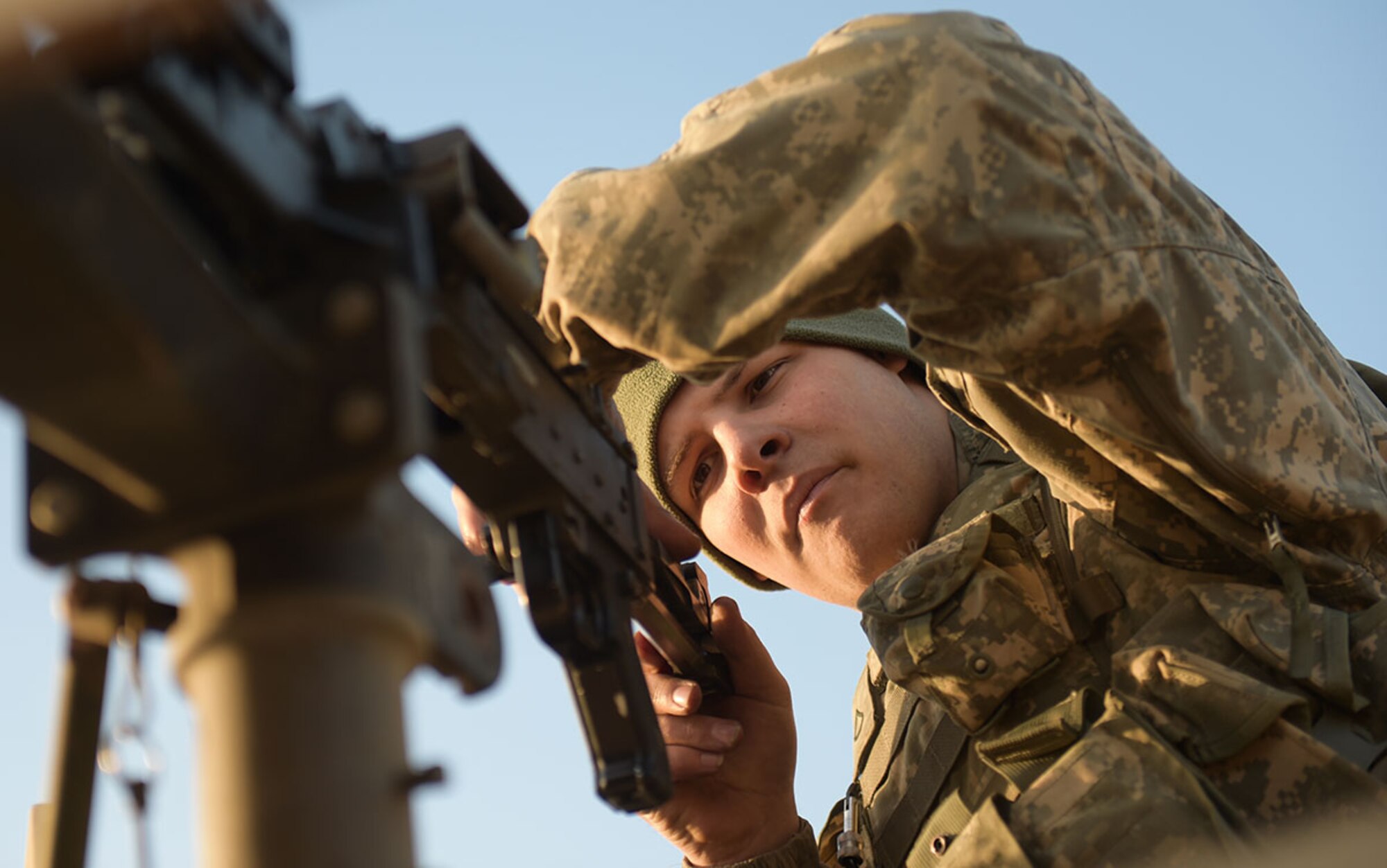 Army Pfc. Jared Weigant, a native of Red Oak, Texas, assigned to U.S. Army Alaska's 109th Transportation Company, inspects the bolt of his machine gun, Thursday, Nov. 13, 2014, on Joint Base Elmendorf-Richardson, Alaska, in preparation for a convoy live-fire exercise.  The soldiers also simultaneously executed react-to-ambush procedures with follow-on hasty and deliberate vehicle recovery operations.  (U.S. Air Force photo/Justin Connaher)