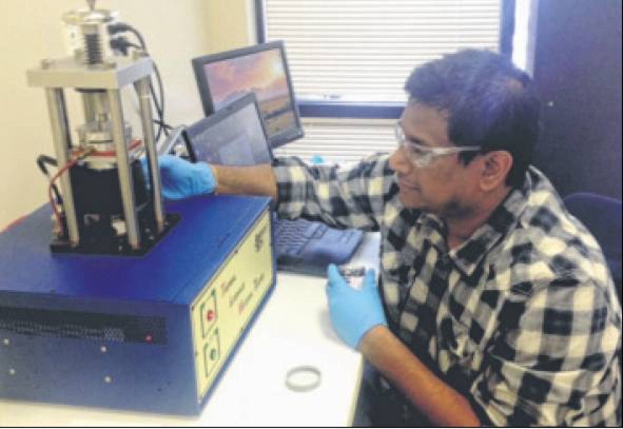 Dr. Sayangdev Naha, ADA Technologies’ principal investigator, tests the thermal resistance of thermal grease in an ASTM D5470 Thermal Interface Material tester. (Courtesy photo)