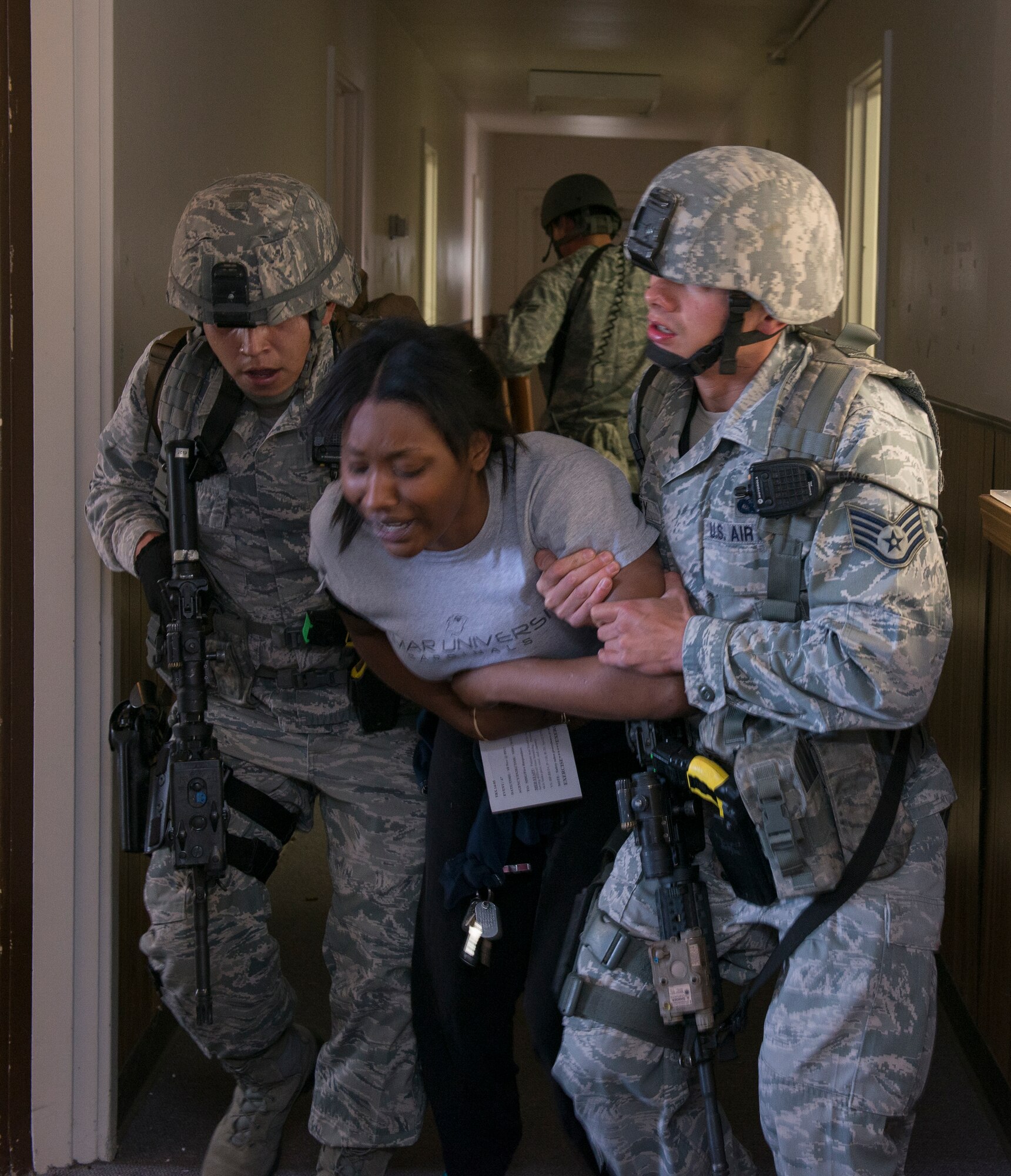 Airmen from the 60th Security Forces Squadron assess simulated victims that had been wounded during an active-shooter exercise Nov. 18, 2014, at Travis Air Force Base, California. The wounded received a card indicating their injuries with descriptions and their vital signs to advise medical responders how to treat each "victim."  (U.S. Air Force photo by Heide Couch)
