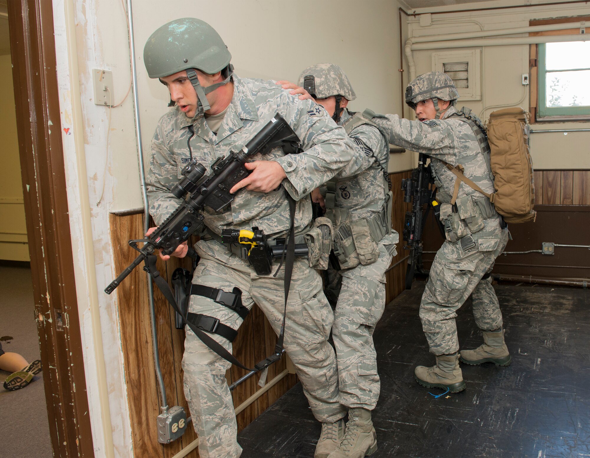 Airmen from the 60th Security Forces Squadron enter a vacant building simulating an active-shooter scenario Nov. 18, 2014, at Travis Air Force Base, California. The Airmen effectively neutralized the shooter and secured the facility. To ensure safety during the exercise, the Airmen traded their real firearms for training weapons. Travis routinely conducts emergency exercises to prepare the base for possible threats, natural disasters and accidents. (U.S. Air Force photo by Heide Couch)
