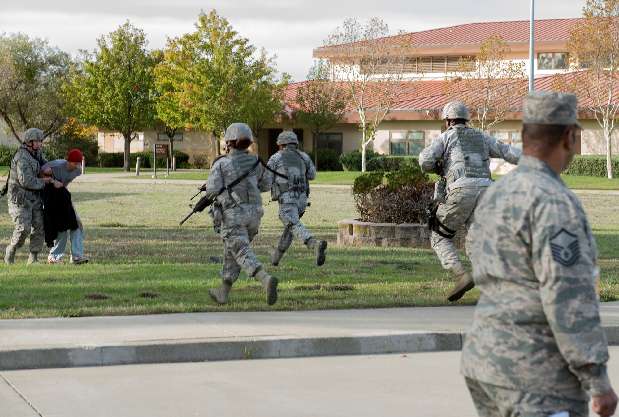 Airmen from the 60th Security Forces Squadron enter a vacant building simulating an active-shooter scenario Nov. 18, 2014, at Travis Air Force Base, California. The Airmen effectively neutralized the shooter and secured the facility. To ensure safety during the exercise, the Airmen traded their real firearms for training weapons. Travis routinely conducts emergency exercises to prepare the base for possible threats, natural disasters and accidents. (U.S. Air Force photo by Heide Couch)