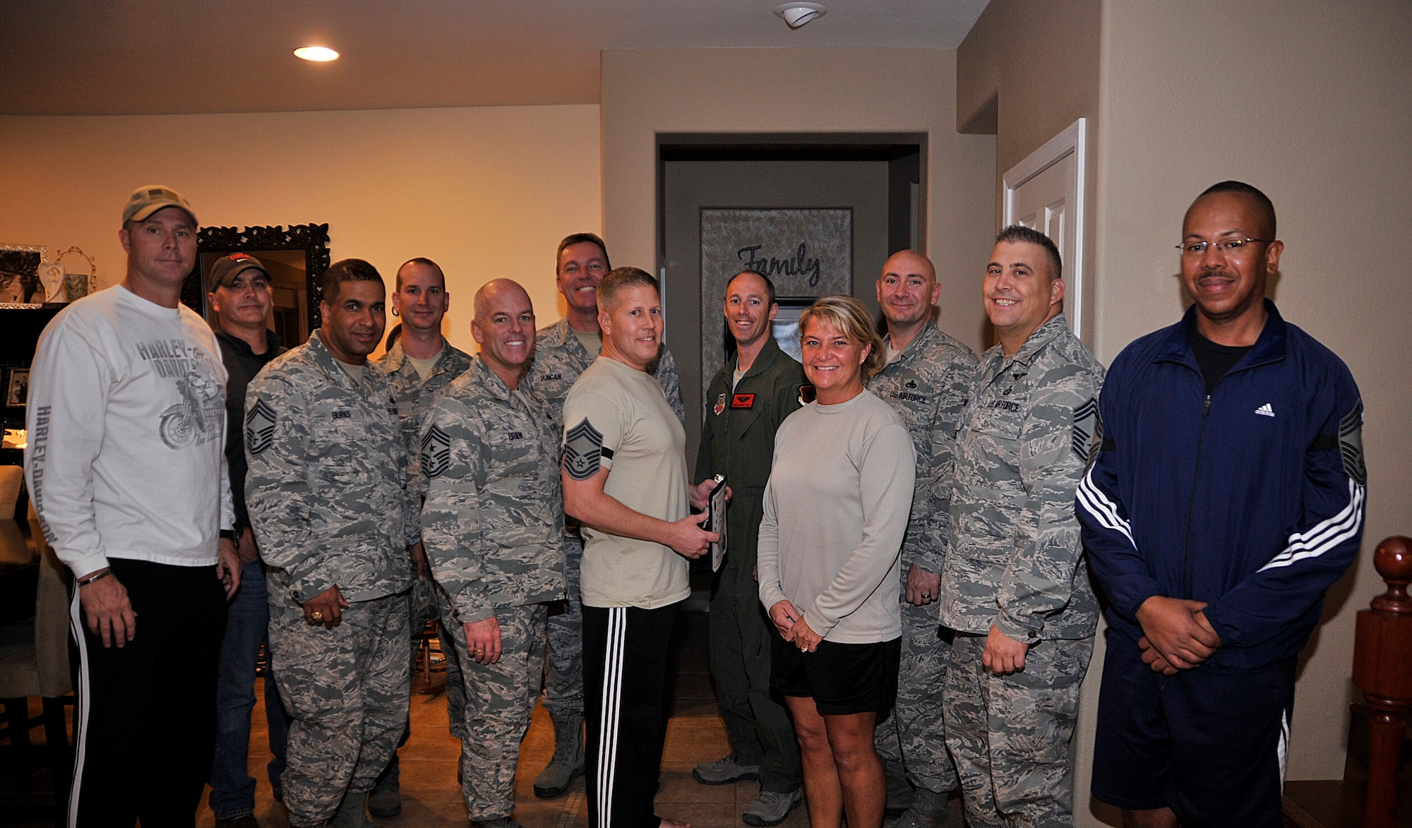 Senior Master Sgt. Matthew Saugstad, center left, poses with his wife Senior Master Sgt. Carissa Saugstad and Chief Master Sgt. Butch Brien, 432nd Wing command chief, and the rest of Creech Air Force Base's chief master sergeants in Las Vegas Nov. 19, 2014.  Saugstad was recently selected for promotion to chief master sergeant, and Creech leadership recognized the achievement with a surprise visit to his home. (U.S. Air Force Photo by Airman 1st Class Christian Clausen/released)

