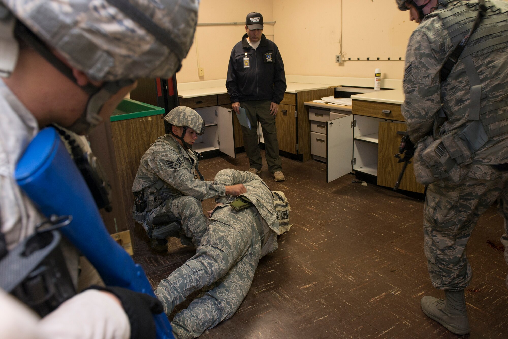 Airmen from the 60th Security Forces Squadron enter a vacant building simulating an active-shooter scenario Nov. 18, 2014, at Travis Air Force Base, California. The Airmen effectively neutralized the shooter and secured the facility. To ensure safety during the exercise, the Airmen traded their real firearms for training weapons. Travis routinely conducts emergency exercises to prepare the base for possible threats, natural disasters and accidents. (U.S. Air Force photo by Heide Couch)