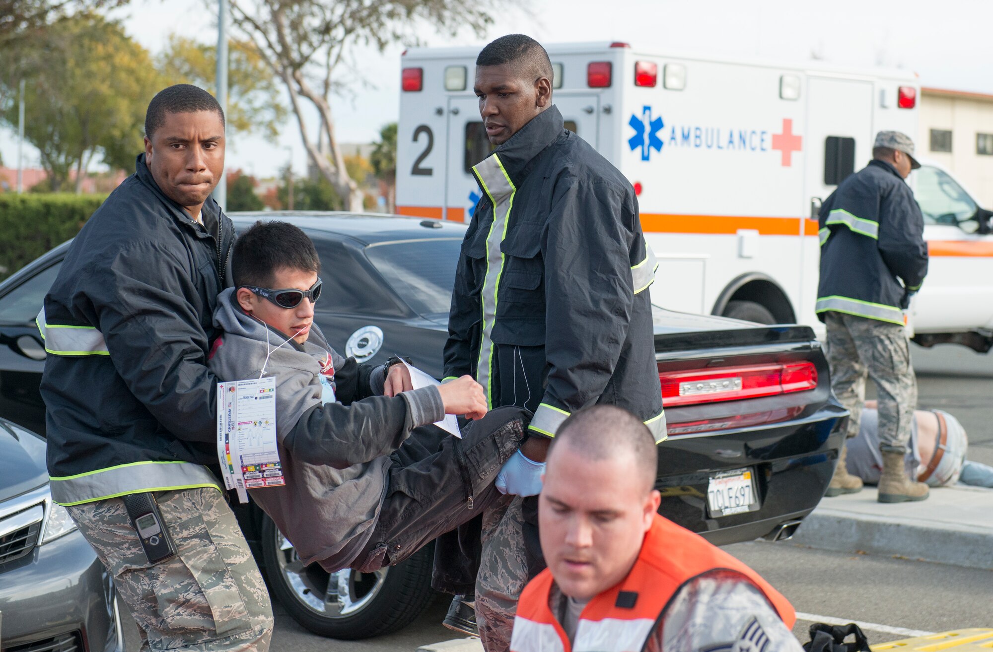 Travis medical staff tend to simulated victims during an active-shooter exercise Nov. 18, 2014, at Travis Air Force Base, California. Simulated victims were added to the scenario to create a sense of realism. The base wide scenario was played out in realistic, gritty detail, all in an effort to prepare emergency personnel and all Travis AFB employees for a potential crisis. (U.S. Air Force photo by Heide Couch)