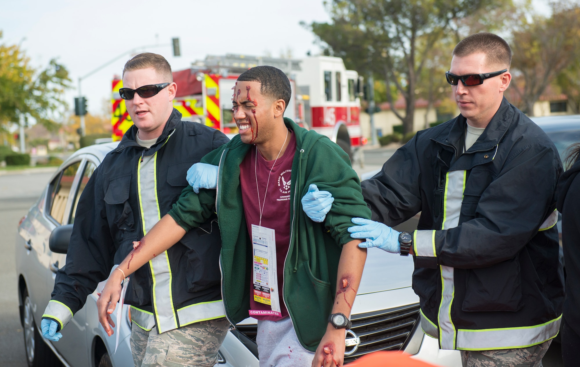 Travis medical staff tend to simulated victims during an active-shooter exercise Nov. 18, 2014, at Travis Air Force Base, California. Simulated victims were added to the scenario to create a sense of realism. The base wide scenario was played out in realistic, gritty detail, all in an effort to prepare emergency personnel and all Travis AFB employees for a potential crisis. (U.S. Air Force photo by Heide Couch)