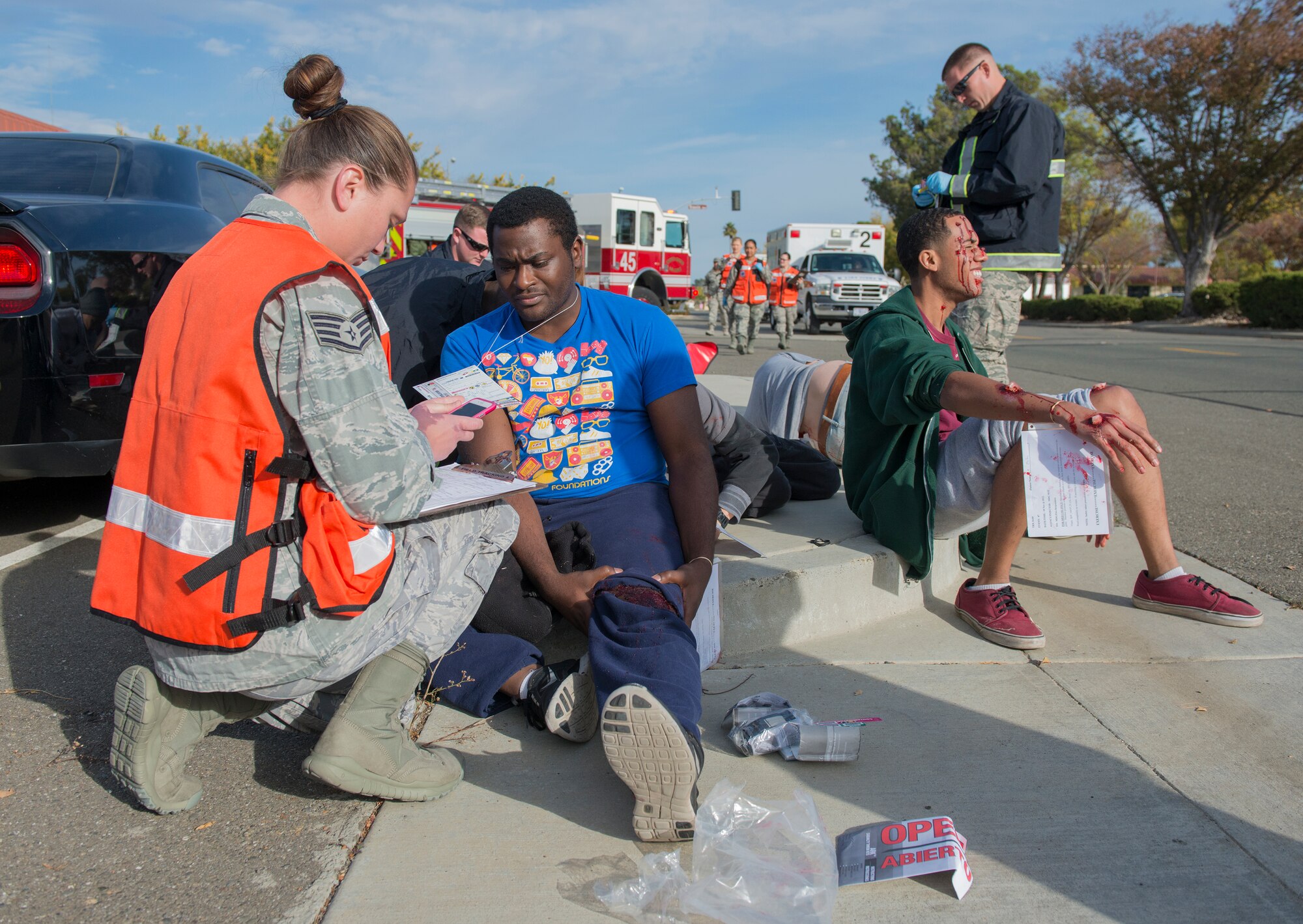 Travis medical staff tend to simulated victims during an active-shooter exercise Nov. 18, 2014, at Travis Air Force Base, California. Simulated victims were added to the scenario to create a sense of realism. The base wide scenario was played out in realistic, gritty detail, all in an effort to prepare emergency personnel and all Travis AFB employees for a potential crisis. (U.S. Air Force Photograph/Heide Couch)