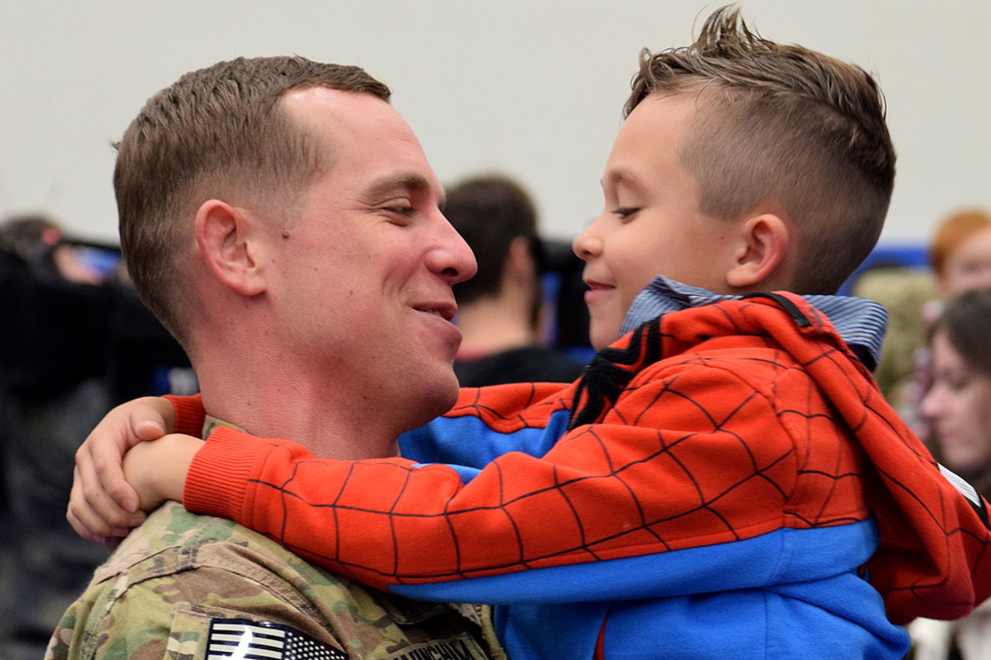 Staff Sgt. Gilbert Cunningham shares a reunion moment with his 6-year-old son, Paxtyn, at the Buckner Physical Fitness Center on Joint Base Elmendorf-Richardson Nov. 18, 2014. About 150 soldiers from the 23rd Sapper Company and 17th Combat Sustainment Support Battalion were met by their families and friends after the soldiers returned from Afghanistan. (Army photo/John Pennell)
