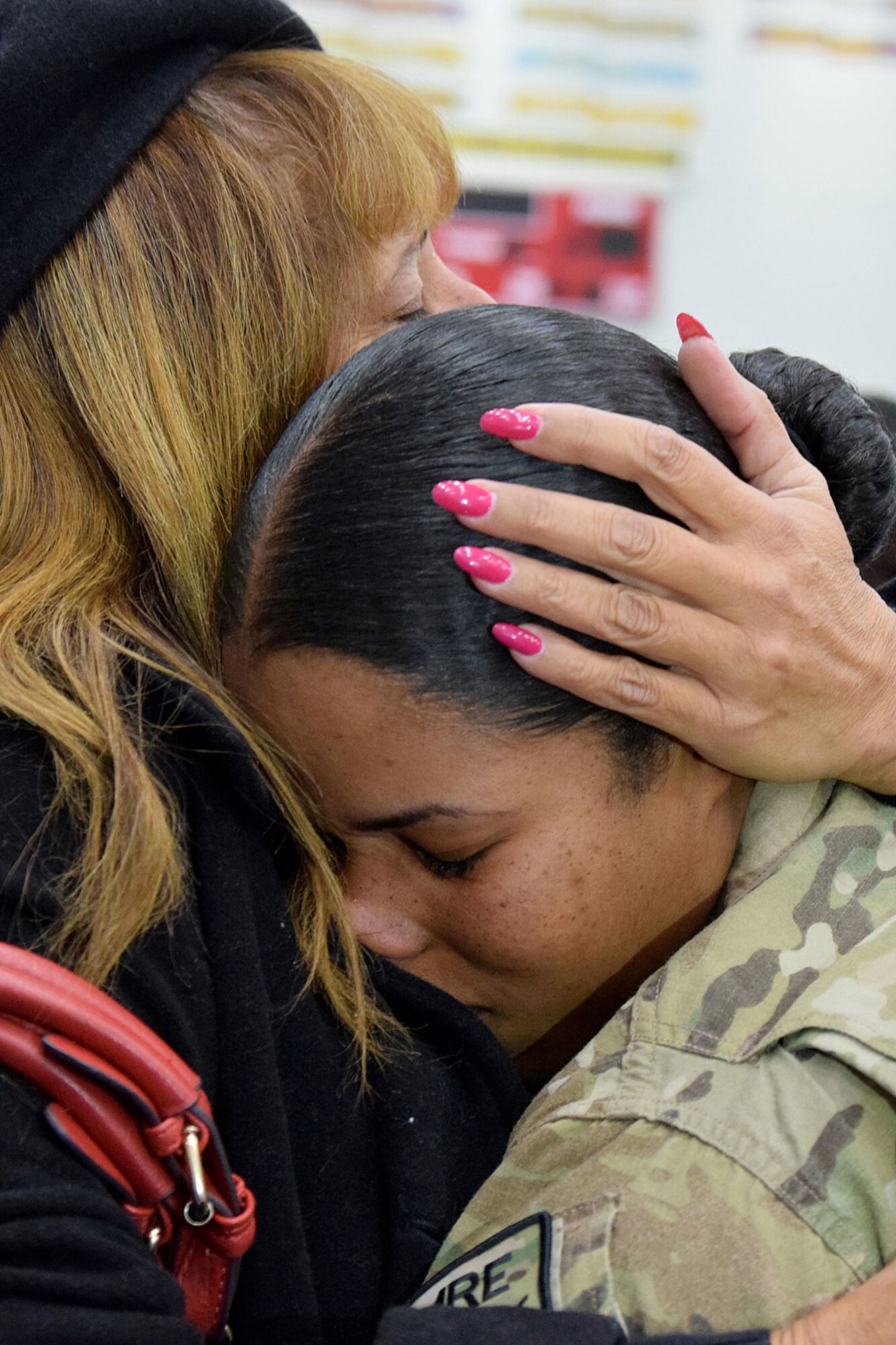 Spc. Denise Charriez, of the 17th Combat Sustainment Support Battalion, shares an extended hug with her mother. Kathy Charriez flew from Florida to Alaska to surprise her daughter at the Buckner Physical Fitness Center on Joint Base Elmendorf-Richardson Nov. 18, 2014. About 150 soldiers from the 23rd Sapper Company and 17th CSSB were met by their families and friends after the soldiers returned from Afghanistan. (Army photo/John Pennell)