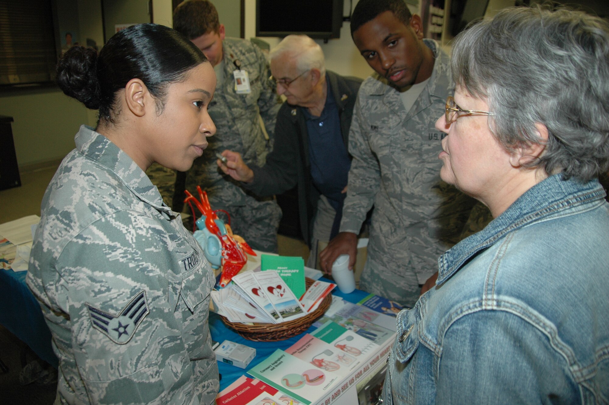 Senior Airman Silkence Troutman and Senior Airman Kasaun Mims, 60th Surgical Operations Squadron medical technicians, meet with a retiree during the Travis Retiree Appreciation Day health fair Nov. 15, at David Grant USAF Medical Center. (U.S. Air Force photo by Jim Spellman)