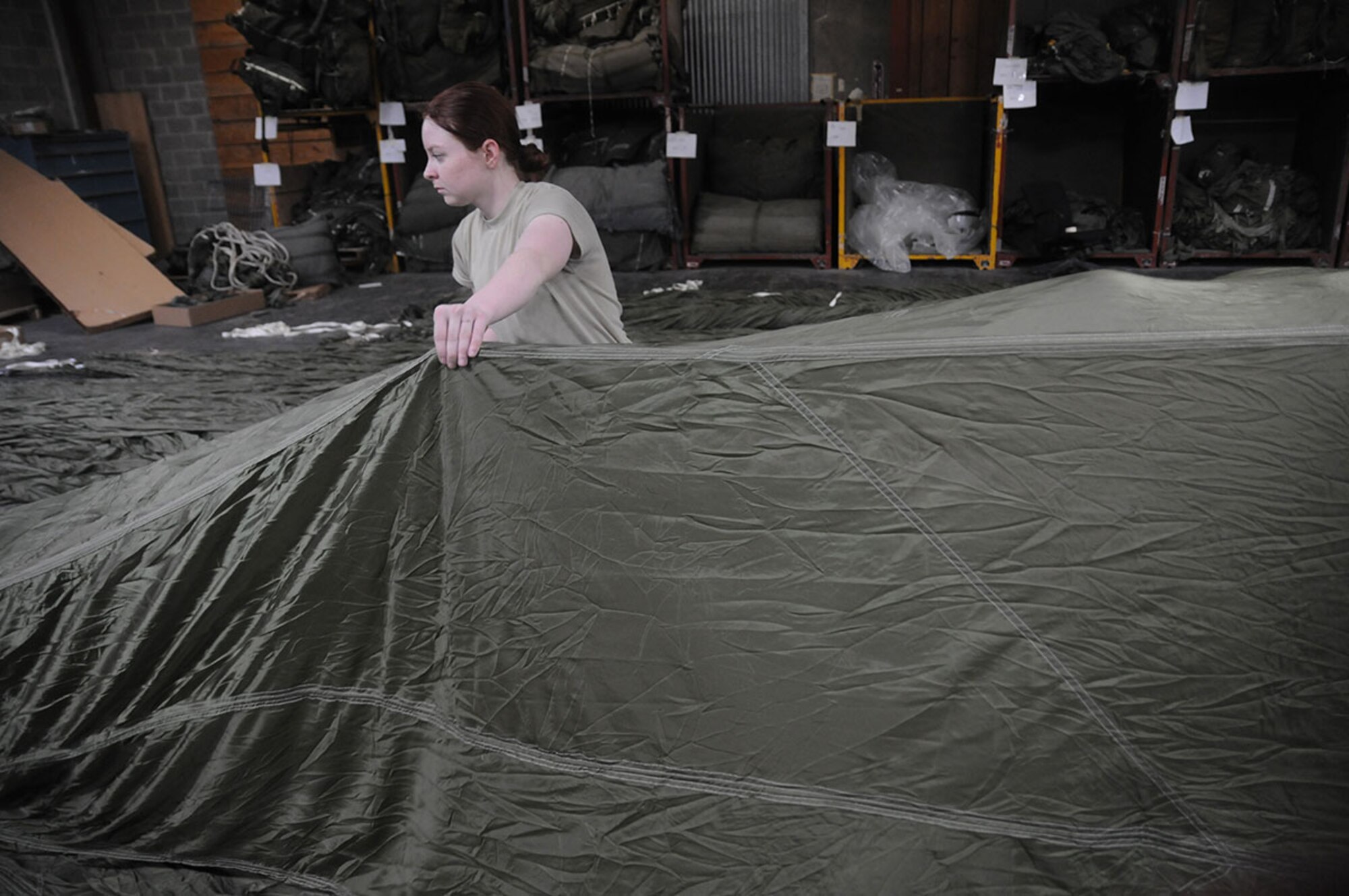 Spc. Katelyn Garrett, a parachute rigger with Headquarters Company, 725th Brigade Support Battalion (Airborne), 4th Infantry Brigade Combat Team (Airborne), 25th Infantry Division, rigs a G-12D cargo parachute during the Best Rigger Competition at the 4th Quartermaster rigging facility at Joint Base Elmendorf-Richardson, Alaska, Nov. 12, 2014. The top performers from the event will go on to represent U.S. Army Alaska in the upcoming Rigger Rodeo event at Fort Bragg in 2015. (U.S. Army photo by Sgt. Brian Ragin/Released)
