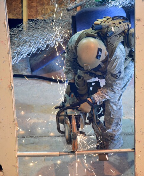 Staff Sgt. Jarrid Wrege, 341st Security Forces Group Tactical Response Force, demonstrates the cutting capability of the K-12 saw during a training exercise at Malmstrom Air Force Base, Mont., Nov. 18.  The K-12 saw is equipped with a diamond blade and is capable of cutting through concrete and metal. (U.S. Air Force photo/Airman 1st Class Joshua Smoot)