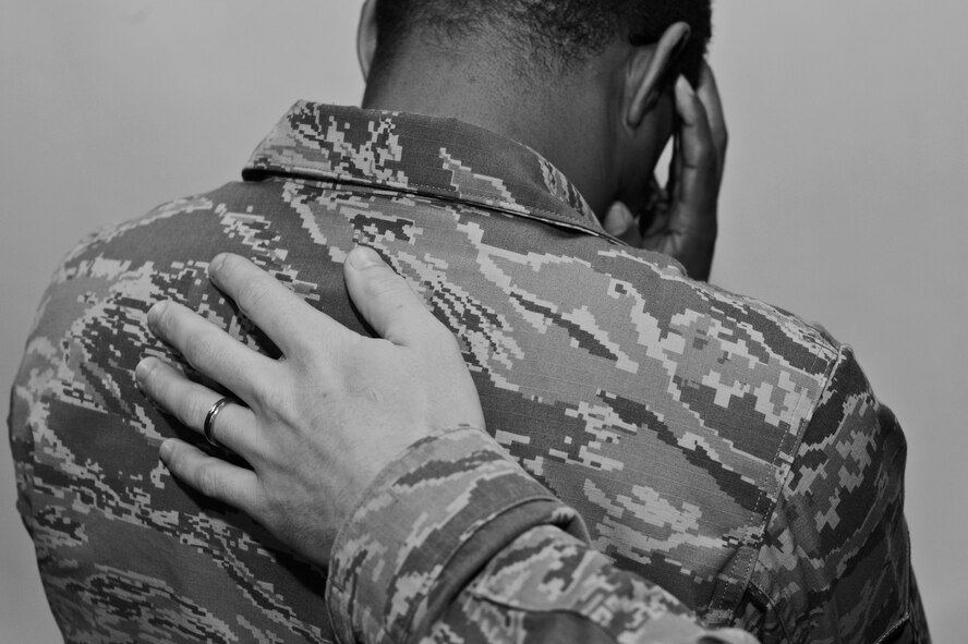 A U.S. Air Force Airman places his hand on another Airman’s back at Shaw Air Force Base, S.C., Nov. 21, 2014. The wingman concept is a simple but critical idea that can be used every day, in many situations. While flying, fighting, and winning, Airmen are obliged to treasure and foster the wingman concept, to take care of each other every day, and to never forget. (U.S. Air Force photo by Senior Airman Tabatha Zarrella/Released)