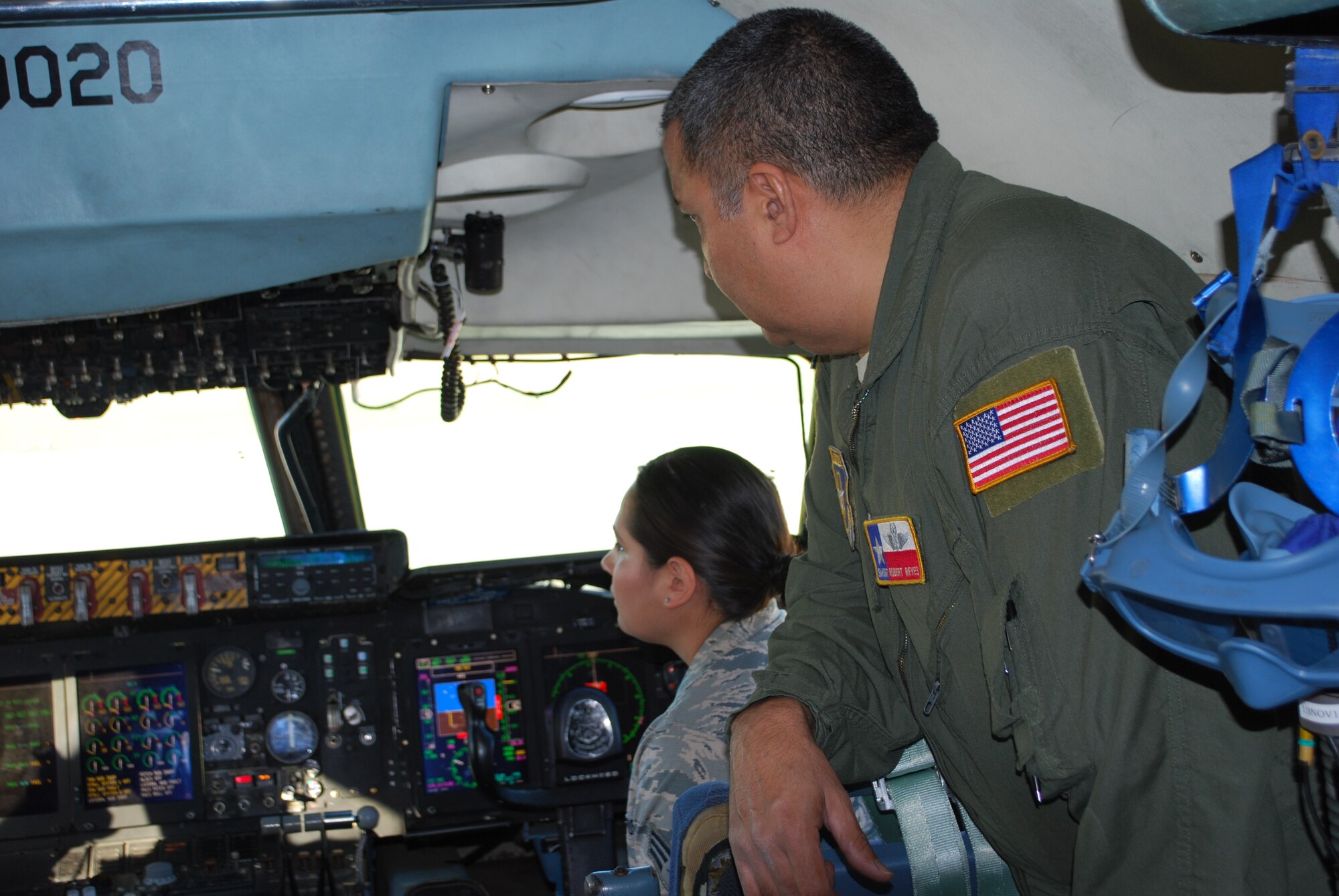 Senior Master Sgt. Robert Reyes (forefront) 68th Airlift Squadron, flight engineer explains the instrument panel in the cockpit, Nov. 1, 2014 to Medical Technician Senior Airmen Jamie Ortega. Ortega from the 433rd Aeromedical Staging Squadron was one of thirteen award members from Joint Base San Antonio-Lackland, Texas, who were treated to an incentive flight sponsored by the 433rd Operations Group, JBSA-Lackland. (U.S. Air Force Photo/Minnie Jones)

