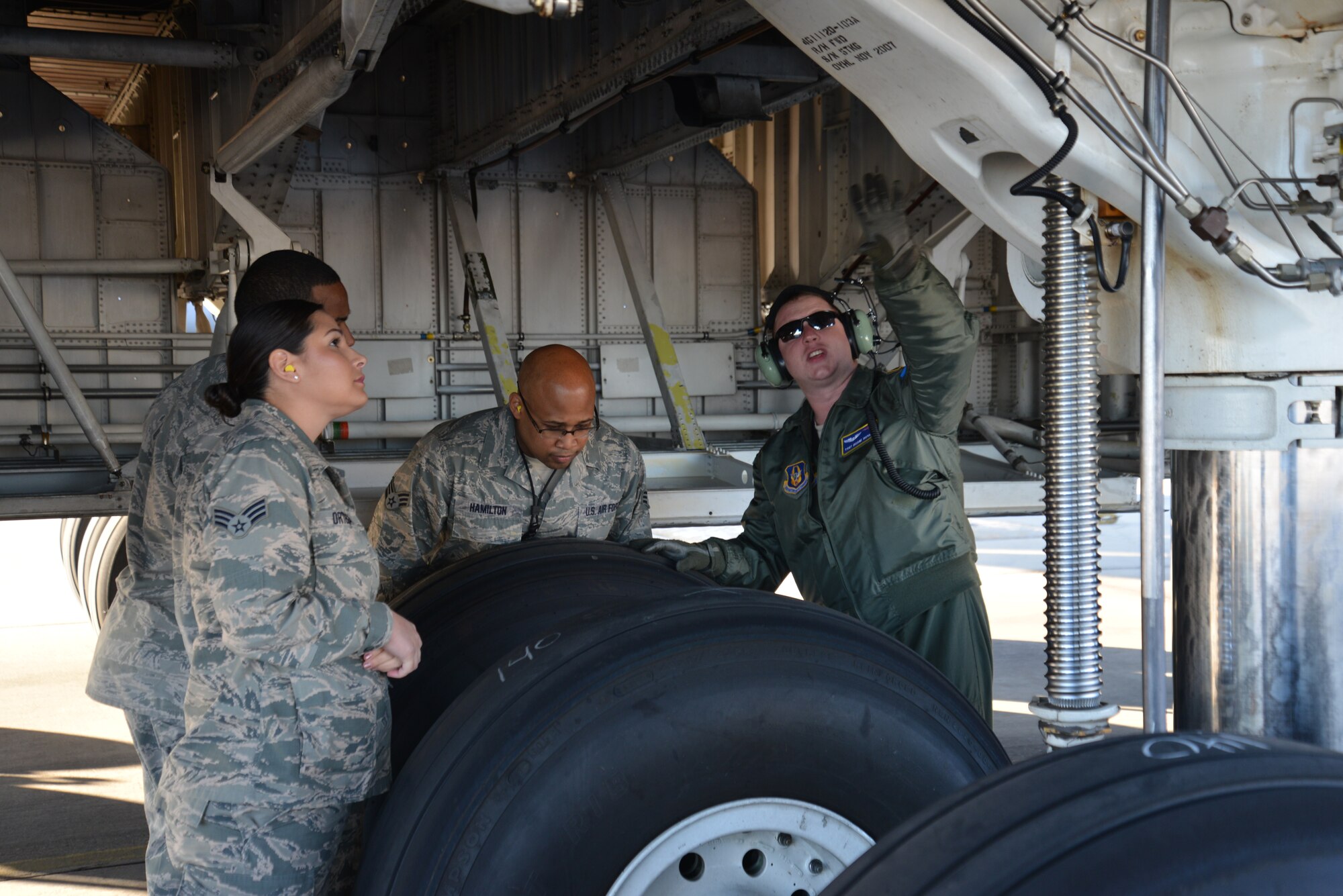Just prior to take-off from Joint Base San Antonio-Lackland, Texas 1 Nov. 2014, Flight Engineer Tech. Sgt. Duane Bryant (right) 337th Airlift Squadron, explains one of the tasks on a C-5A pre-flight inspection, which includes a thorough external look of the aircraft to Senior Airman Mychal Hamilton, an Aerospace Ground Equipment Specialist with 433rd Maintenance Squadron and Medical Technician Senior Airmen Jamie Ortega (forefront left) from the 433rd Aeromedical Staging Squadron. JBSA-Lackland Airmen were given an incentive flight courtesy of the 433rd Operations Group. (U.S. Air Force Photo/Minnie Jones)