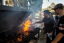 U.S. Air Force Senior Airman Bailey Benavides, 74th Aircraft Maintenance Unit weapons load crewmember, tends the grill at Weapons Fest Nov. 15, 2014, at Grassy Pond in Lake Park, Ga. Weapons Fest is a traditional Air Force event meant to bring Airmen and their families together. (U.S. Air Force photo by Airman 1st Class Ryan Callaghan/Released)