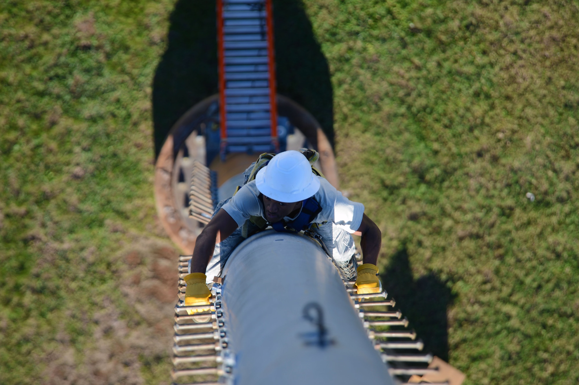 U.S. Air Force Airman 1st Class Ernest Kuma, 20th Civil Engineer Squadron electrical systems apprentice, climbs a ramp tower at Shaw Air Force Base, S.C., Oct. 16, 2014. During the climb, Kuma gripped approximately 90 pegs to pull his way up the 110 foot tower. (U.S. Air Force photo by Airman 1st Class Jensen Stidham/Released) 