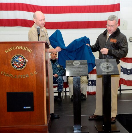 Cmdr. Patrick Boyce, Naval Consolidated Brig Charleston commanding officer (right), and Cmdr. Joseph Cole, NCBC executive officer, unveil two plaques Nov. 21, 2014, in honor of the anniversary of the Brig's commissioning 25 years ago. To date, 8,234 prisoners have been incarcerated at the NCBC, receiving rehabilitative treatment in order to return to honorable service as possible or, barring that, returnto civilian life as productive citizens. The Brig has more than 200 staffers, consisting of Navy, Air Force, Marine Corps and Army active-duty military and civilians. (U.S. Air Force photo/Eric Sesit)