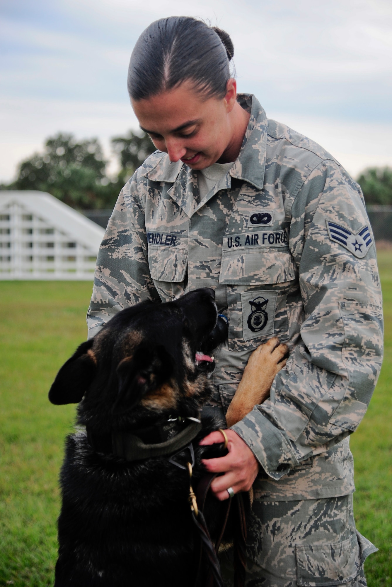 Senior Airman Ashley Wendler, 6th Security Forces Squadron military working dog handler, holds her partner, MWD Alex, as he gives her a dog toy at MacDill Air Force Base, Fla., Nov. 18, 2014. The two spend numerous hours together to train and build rapport in order to become a successful dog team. (U.S. Air Force photo by Airman 1st Class Danielle Conde/Released)
