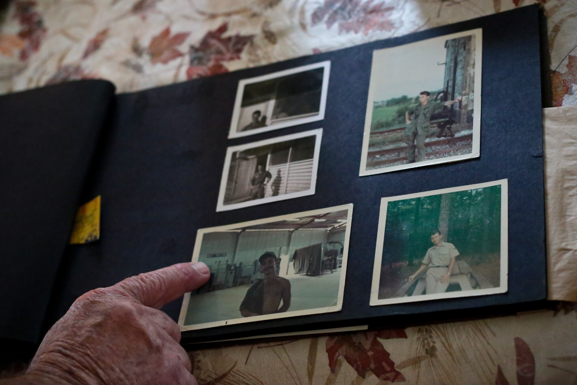 A picture of retired New Jersey Air National Guard Master Sgt. Bob Hensel pointing out old photos in his home.