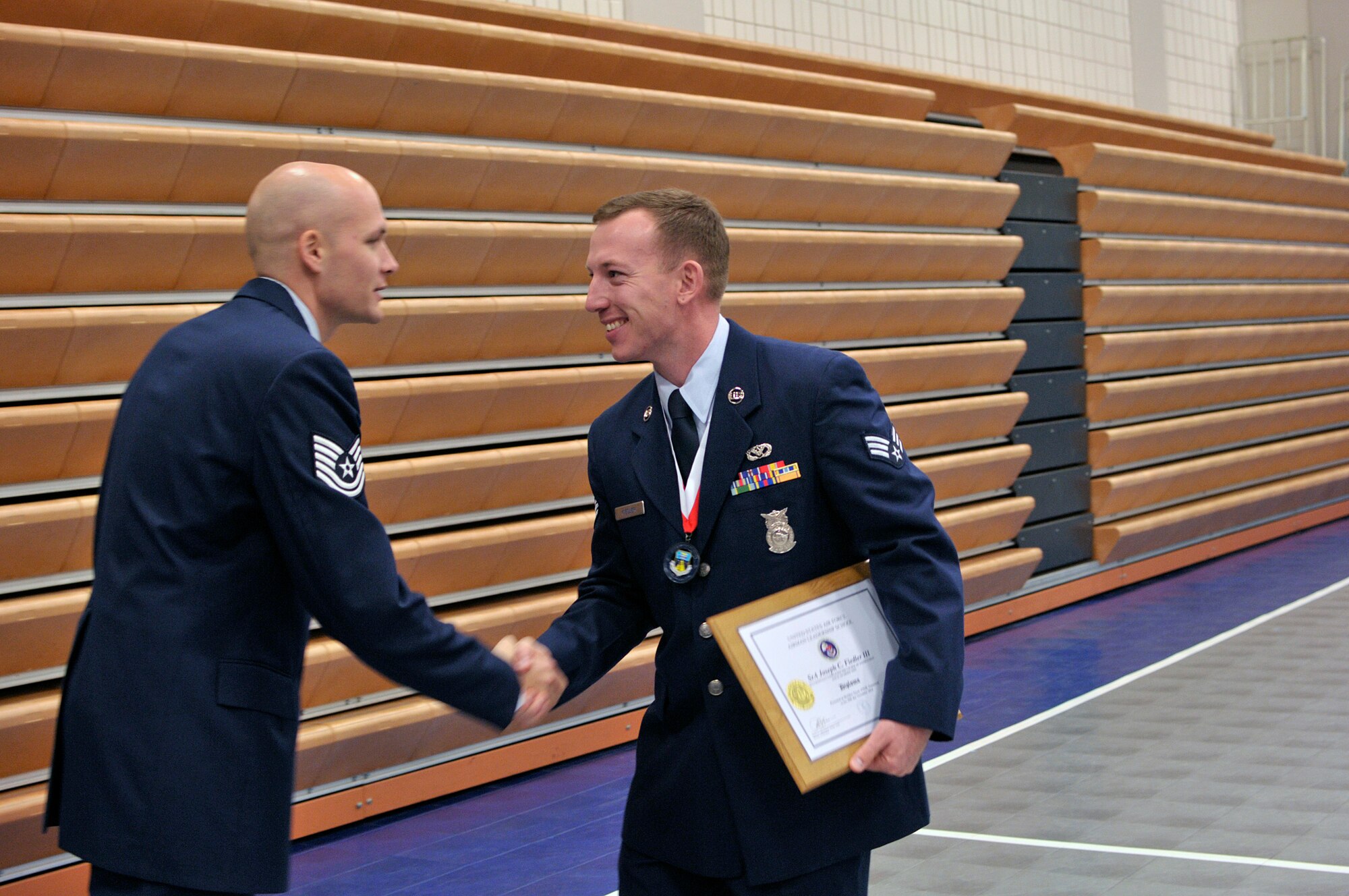 MCGHEE TYSON AIR NATIONAL GUARD BASE, Tenn. - Senior Airman Joseph C. Fiedler III, right, shakes hands with his Airman Leadership School instructor Tech. Sgt. John McClean after receiving his diploma at the I.G. Brown Training and Education Center here Nov. 20 during his class graduation ceremony. At least 273 Airmen and three Coast Guardsmen made up the Paul H. Lankford Enlisted Professional Military Education Center's graduated NCO Academy Class 15-1 and Airman Leadership School Class 15-1. (U.S. Air National Guard photo by Master Sgt. Mike R. Smith/Released)