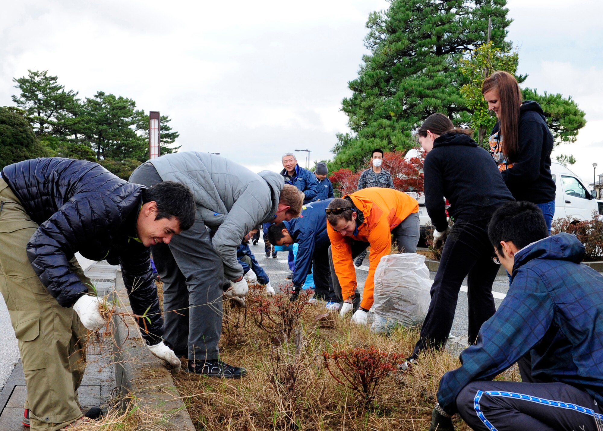 Volunteers from the U.S. Air Force, Japan Air Self-Defense Force and Kinki-Chubu Defense Bureau pulled weeds and dead grass in an effort to clean up a park in Komatsu, Japan, Nov. 15, 2014. The volunteers used their day off to give back to the community by pulling weeds, picking up trash, raking leaves, sweeping sidewalks and cleaning gutters in a local park. The 35th Fighter Wing from Misawa Air Base, Japan was at Komatsu Air Base for an Aviation Training Relocation Program. The 212th Rescue Squadron from Joint Base Elmendorf-Richardson, Alaska and the 33rd RQS from Kadena Air Base, Japan were at Komatsu Air Base for exercise Keen Sword. The joint training conducted during exercise Keen Sword and in the ATR developed bilateral working relationships and allowed for the practice and evaluation of coordination procedures and interoperability elements required to respond to the defense of Japan, or to a regional crisis. (U.S. Air Force photo by 2nd Lt. Erik Anthony/Released)