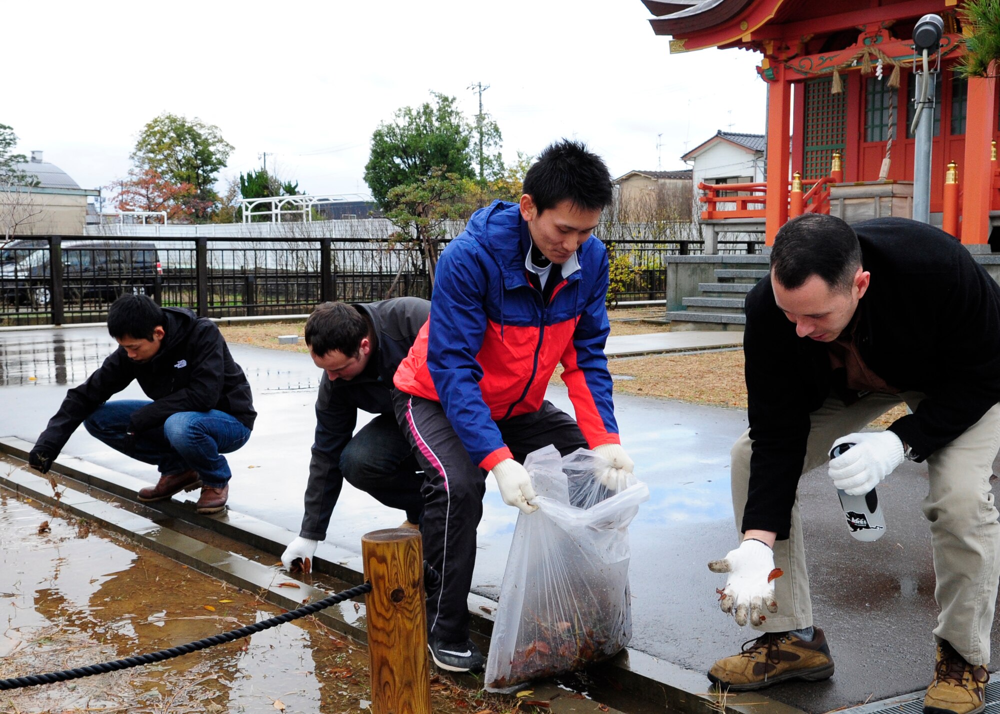 Volunteers from the U.S. Air Force and Japan Air Self-Defense Force clean leaves out of gutters at a local park in Komatsu, Japan, Nov. 15, 2014. The volunteers teamed up members from the Kinki-Chubu Defense Bureau and pulled weeds, picked up trash, raked leaves and swept the sidewalk in an effort to clean up the park. The 35th Fighter Wing from Misawa Air Base, Japan was at Komatsu Air Base for an Aviation Training Relocation Program. The 212th Rescue Squadron from Joint Base Elmendorf-Richardson, Alaska and the 33rd RQS from Kadena Air Base, Japan were at Komatsu Air Base for exercise Keen Sword. The joint training conducted during exercise Keen Sword and in the ATR developed bilateral working relationships and allowed for the practice and evaluation of coordination procedures and interoperability elements required to respond to the defense of Japan, or to a regional crisis. (U.S. Air Force photo by 2nd Lt. Erik Anthony/Released)