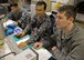 Japanese Air Self Defense Force Warrant Officer Tadahiro Hashinoki (center) and U.S. Air Force Staff Sgt. Jacob Larman (right) review Aviation Training Relocation flight schedules at Komatsu Air Base, Japan, Nov. 14, 2014. As maintenance operations center controllers, Hashinoki and Larman dispatch resources from their respective Forces for scheduled and unscheduled maintenance, and tracks maintenance actions, sorties and incidents such as in-flight emergencies and injured personnel. Larman, who is assigned to the 35th Maintenance Group at Misawa Air Base, Japan, is at Komatsu with more than 120 other Airmen from Misawa, supporting ATR missions. (U.S. Air Force photo by Staff Sgt. Alyssa C. Wallace)