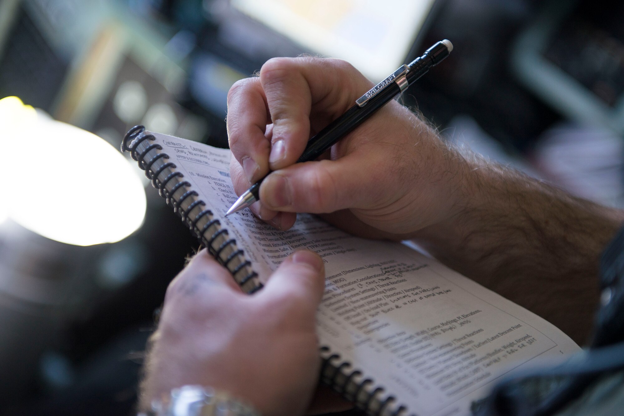 Maj. Andrew Baker, 36 Airlift Squadron weapons and tactics flight commander, takes notes during Exercise Max Thunder over South Korea, Nov. 19, 2014. Baker conducted weeks of preparation and planning to ensure members of the 36 AS were ready to participate in the biannual exercise, and took notes during the mission to improve mission planning for future exercises. (U.S. Air Force photo by Staff Sgt. Cody H. Ramirez/Released)