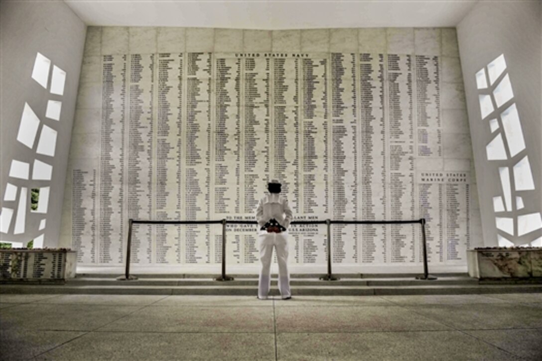 Navy Petty Officer 2nd Class Jennifer Usenick reads the list of fallen military members at the USS Arizona Memorial in Pearl Harbor, Hawaii, Nov. 7, 2014. The memorial marks the resting place of more than 1,000 sailors and Marines who were killed aboard the battleship USS Arizona during the attack on Pearl Harbor.