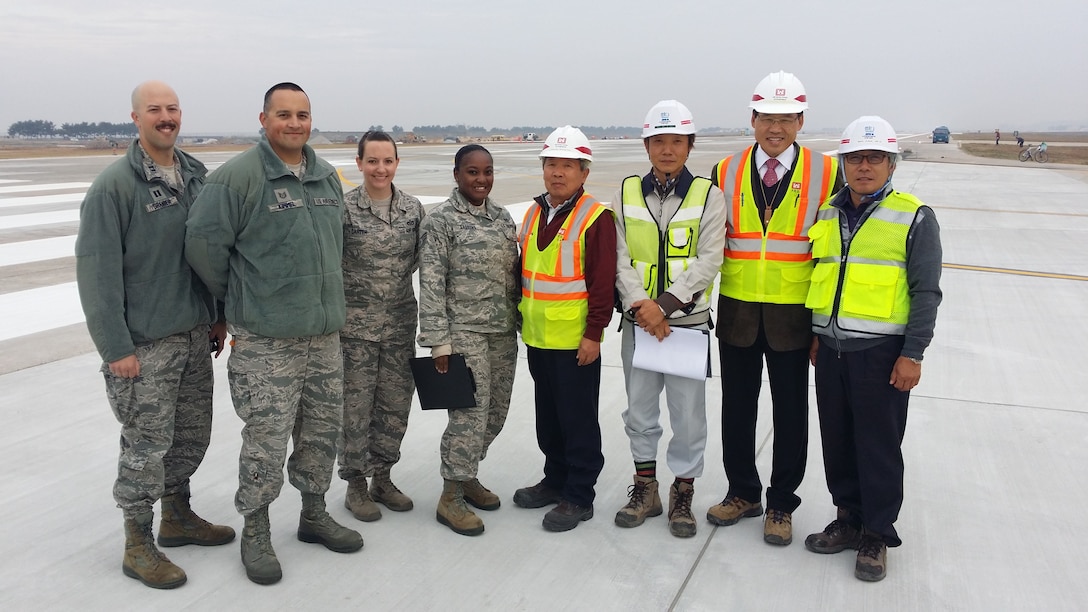 Chong Song-Ho, Kunsan resident office quality assurance representative (4th from right) and Kim U-Kon, Kunsan resident office project engineer (2nd from right) are joined by Airmen from the 8th Civil Engineer Squadron and representatives from Yi Bon Construction Company LTD.