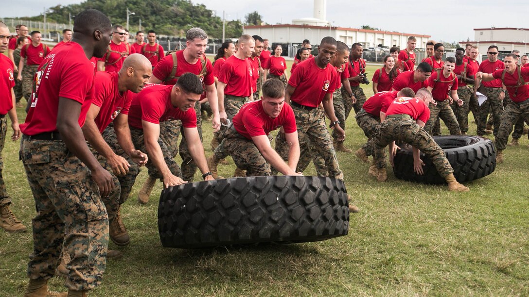 Marines work together to flip 7-ton truck tires Nov. 14 on Camp Hansen’s Parade Field during a 3rd Intelligence Battalion field meet. The friendly competition between the battalion’s three companies brought Marines together to pair off in a test of physical skill, strength, and endurance. The Marines are with 3rd Intel. Bn., III Marine Expeditionary Force Headquarters Group, III MEF. 